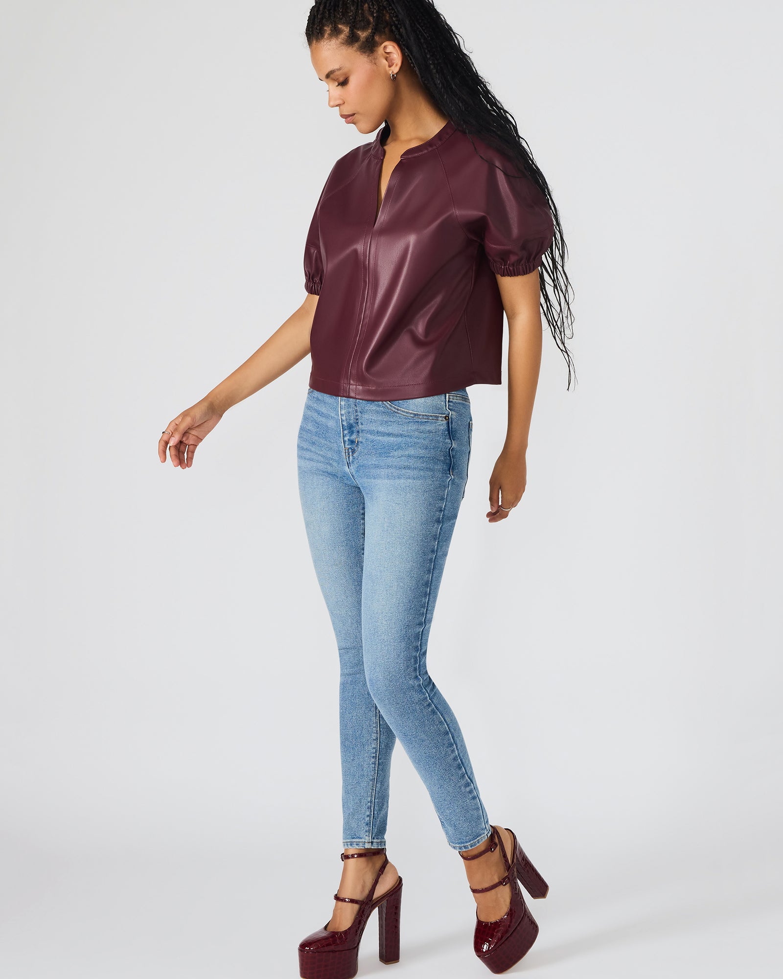 Close-up of the faux leather material on the puff sleeve top, emphasizing its luxurious texture