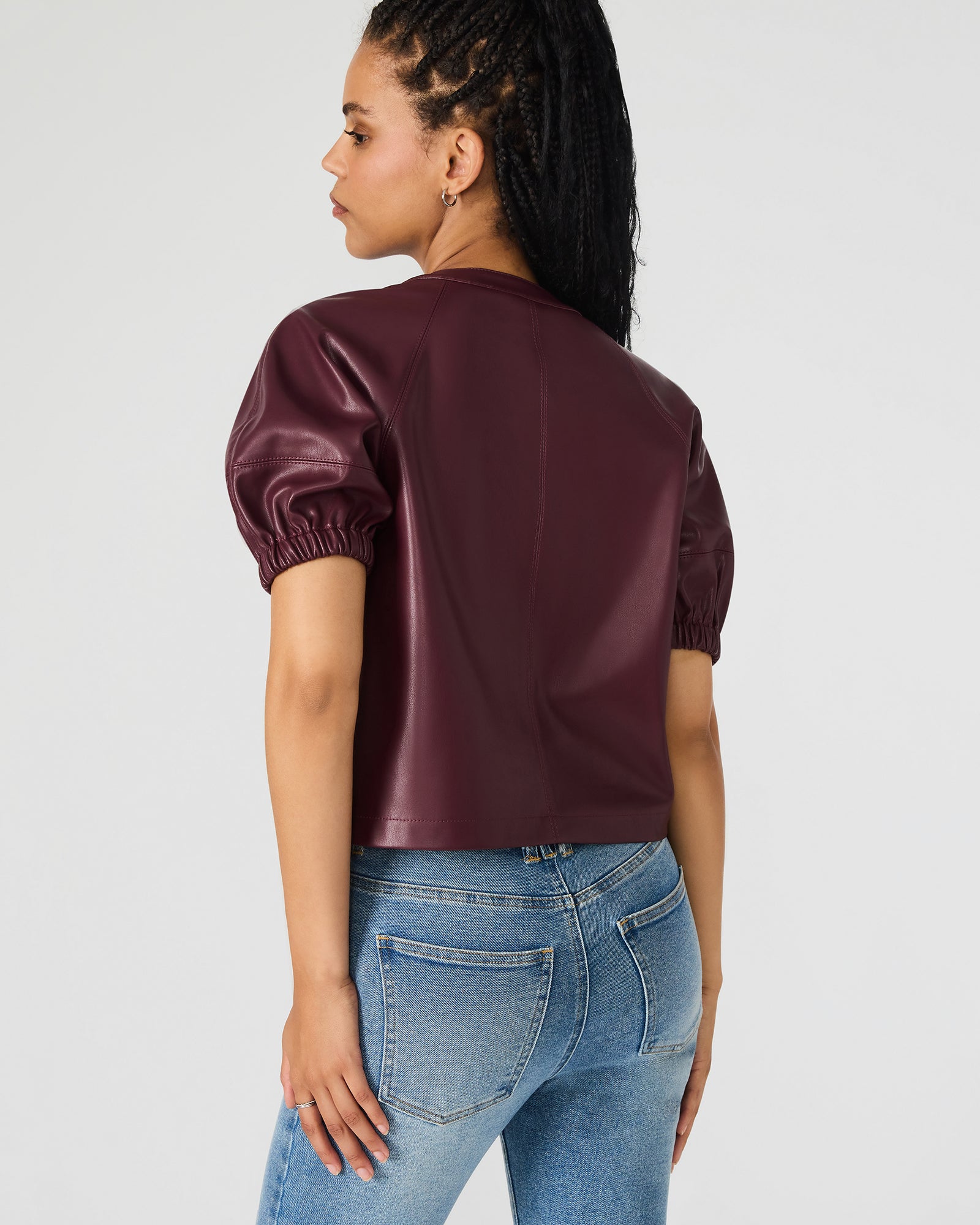 Model showcasing the faux leather puff sleeve top with off-the-shoulder style for a trendy look