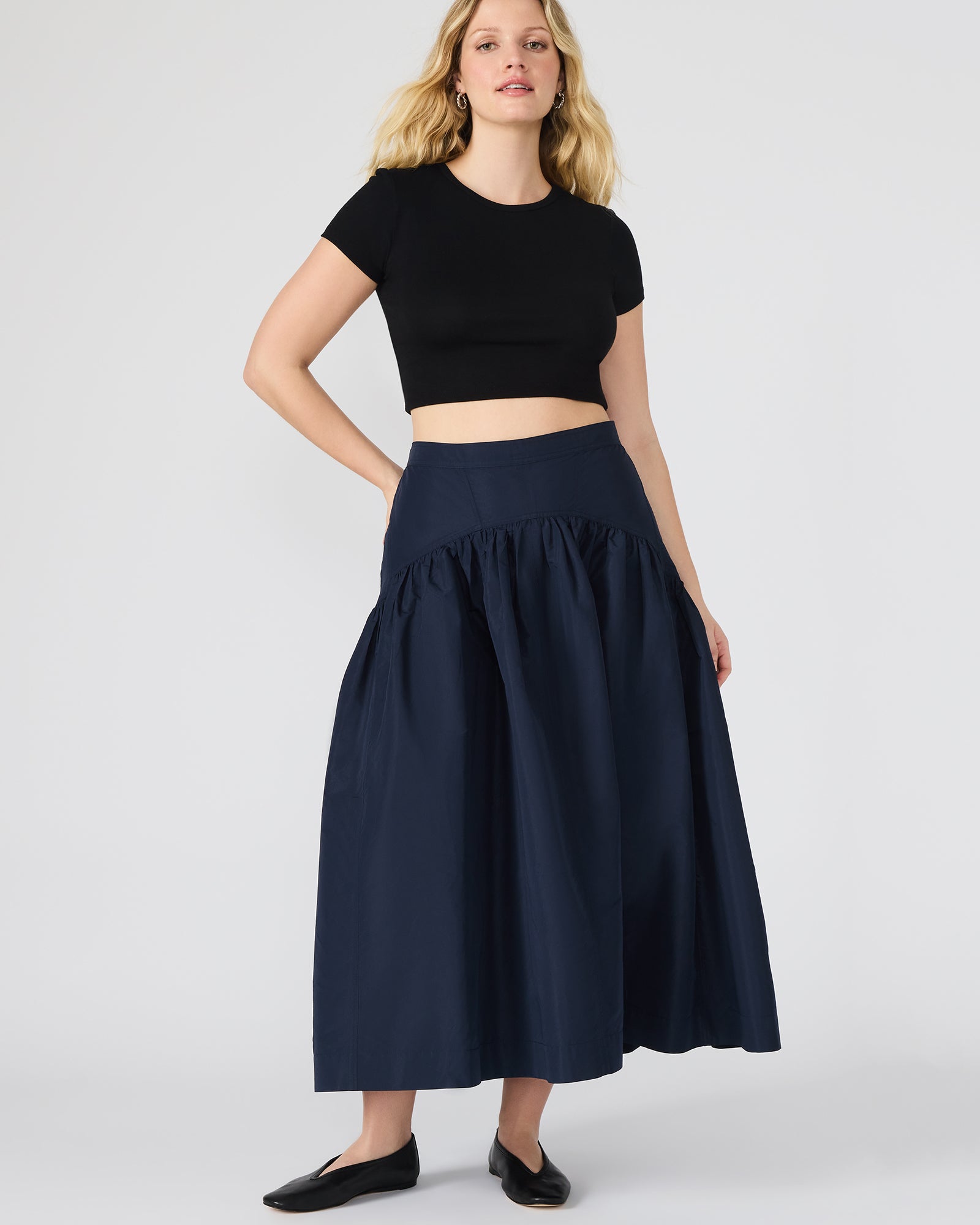 Black maxi skirt side view, flowing hem on styled mannequin