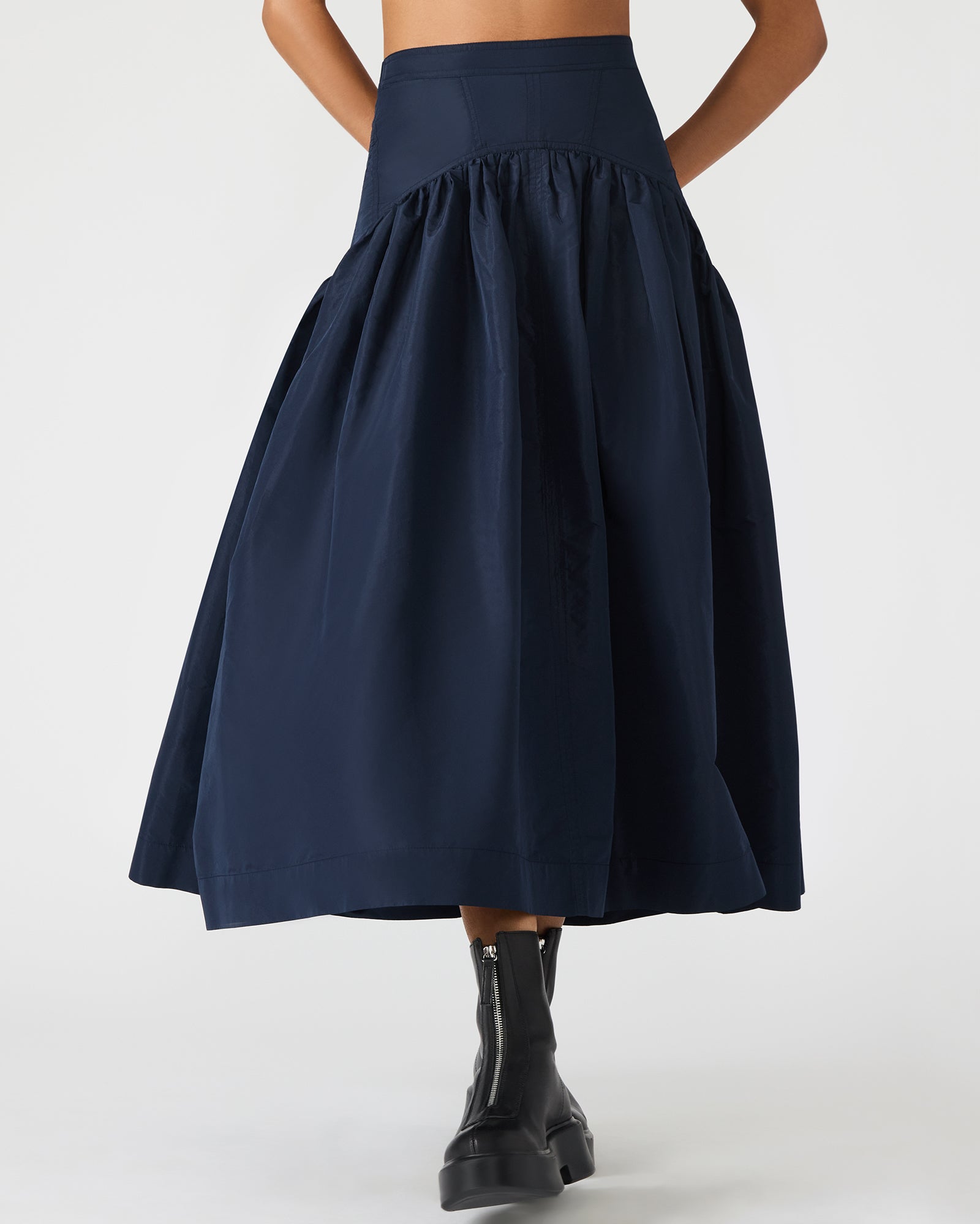 Black maxi skirt side view, flowing hem on styled mannequin