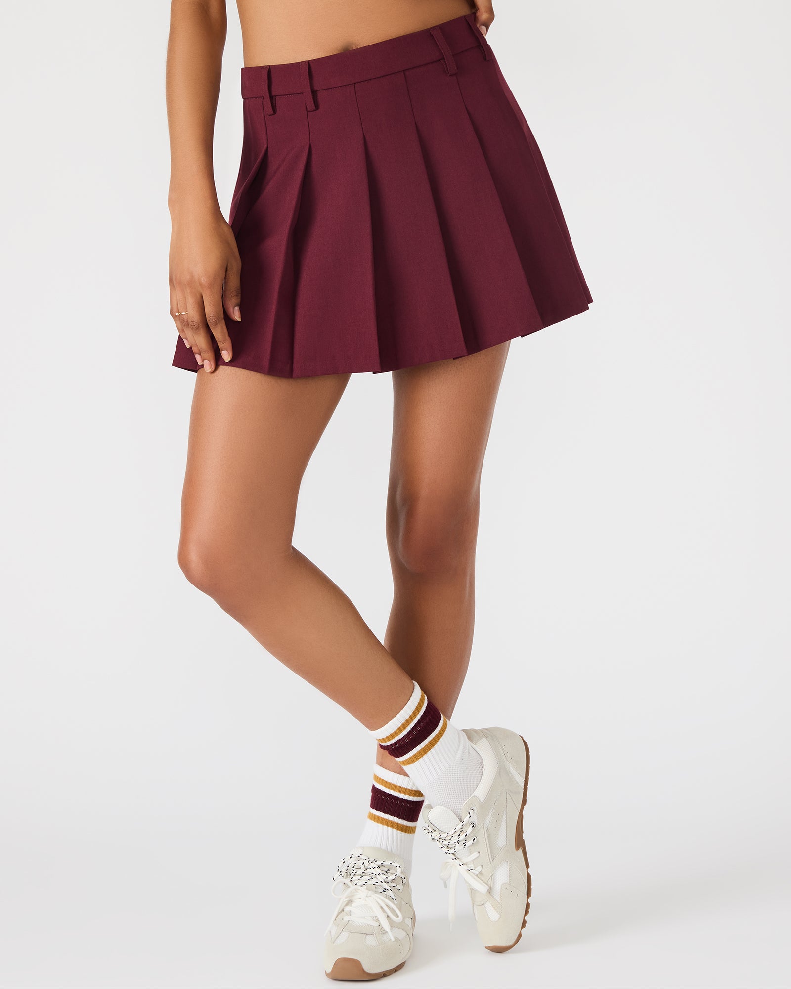 Close-up of pleated detail on wine mini skirt with natural lighting