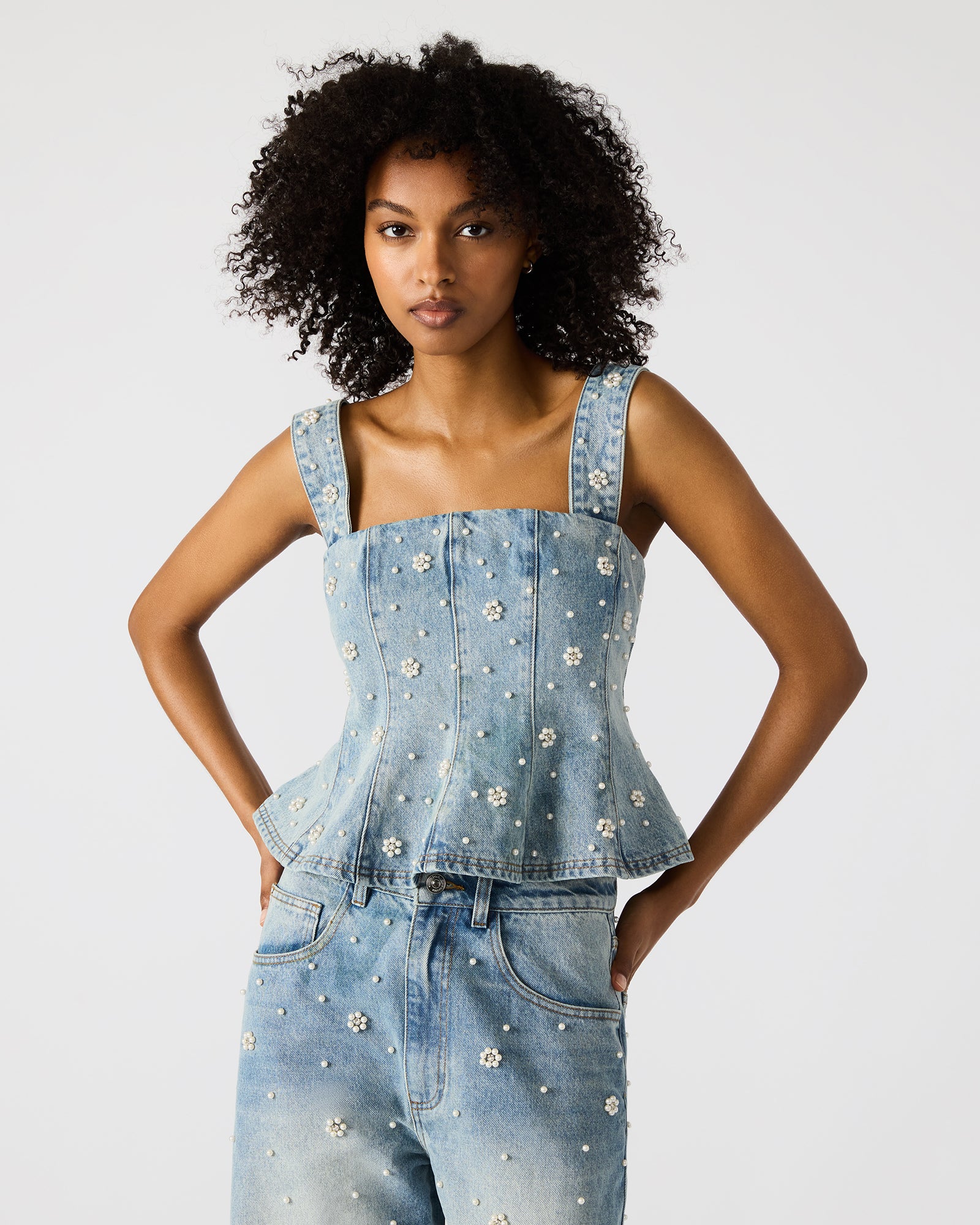 Front view of the denim tank top showing pearl embellishments and ruffled detail