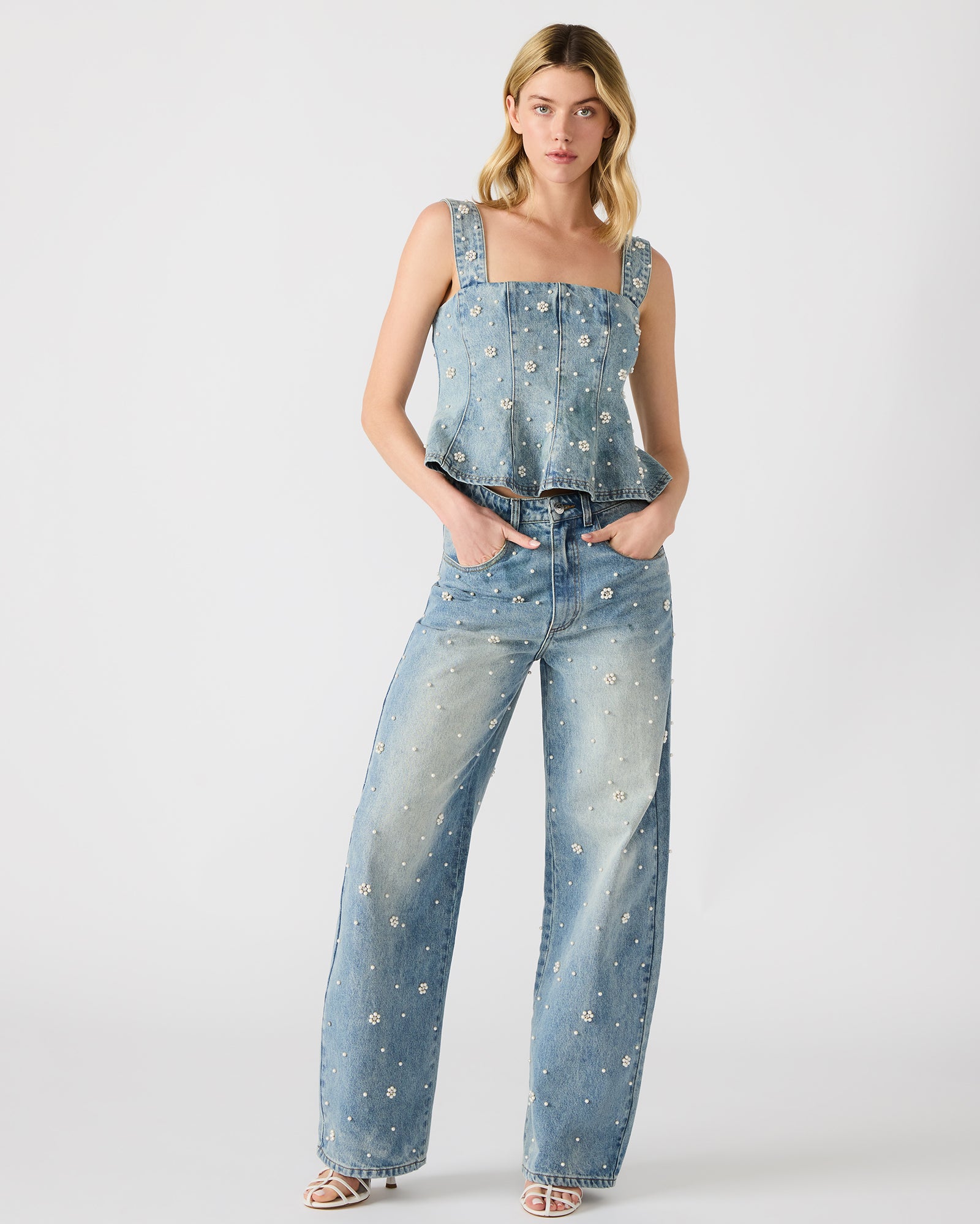 Front view of the denim tank top showing pearl embellishments and ruffled detail