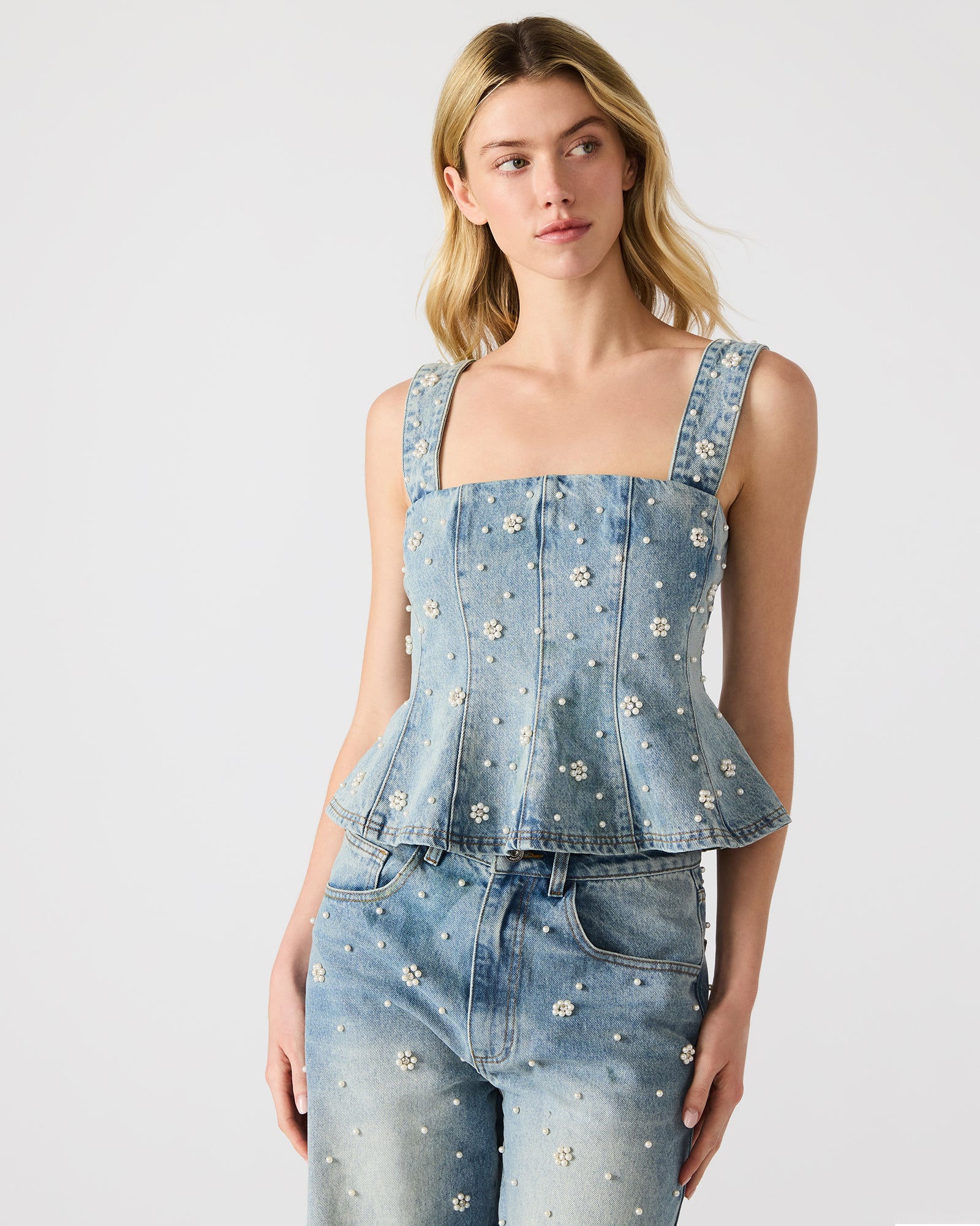 Close-up of the white pearl embellished top highlighting floral accents