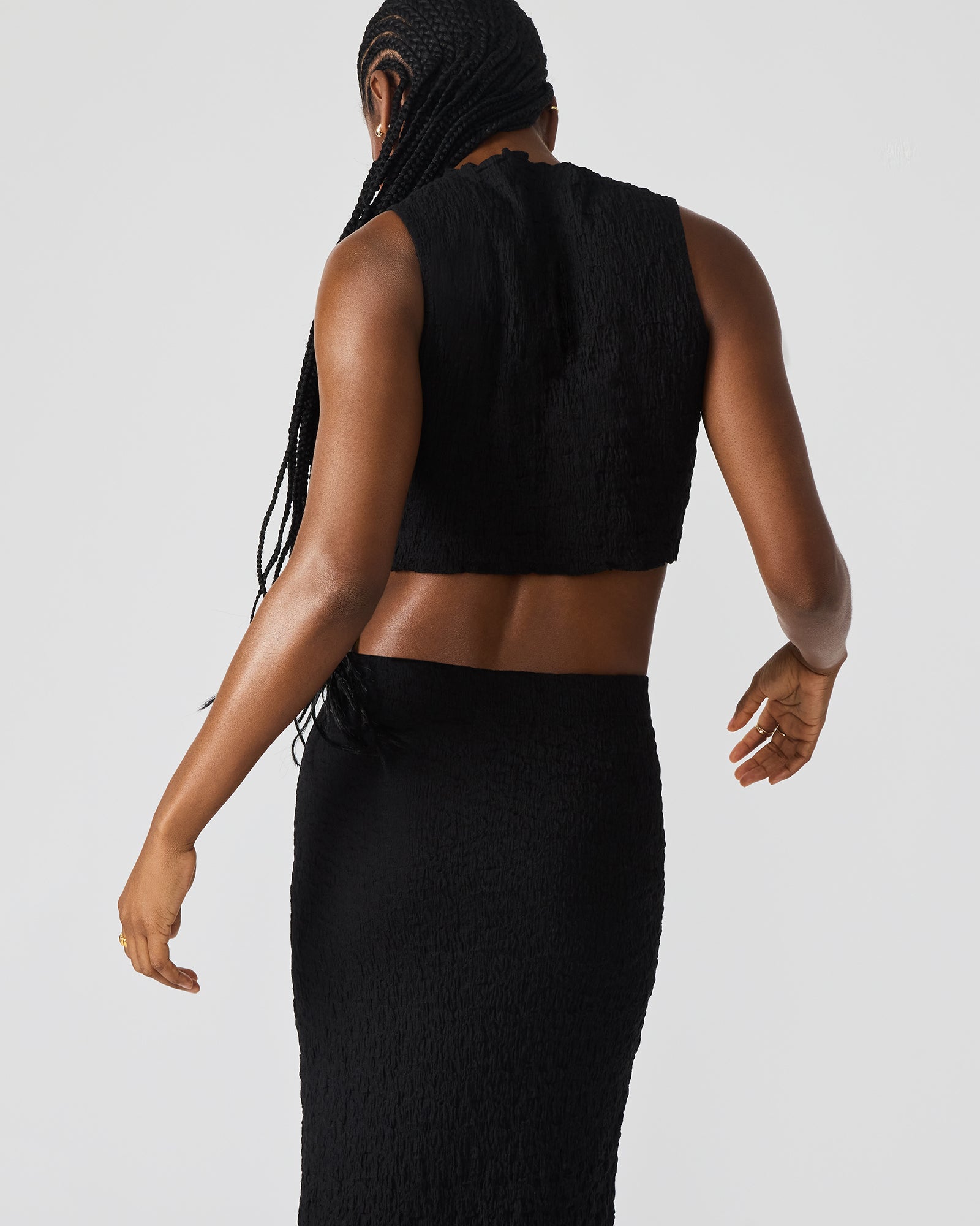 Black seaside maxi skirt set worn with sandals on a sunny day.