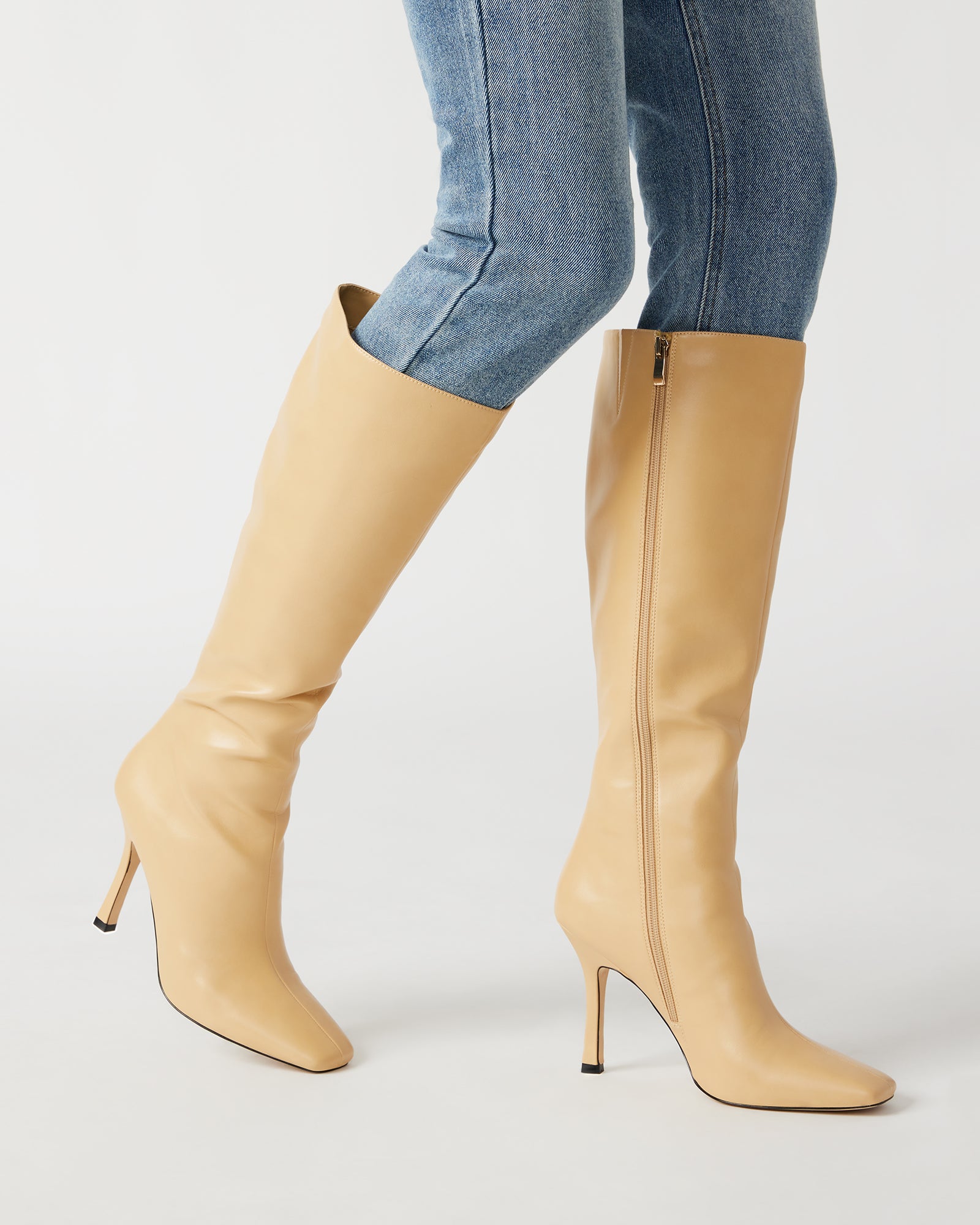 Side view of vegan leather knee high boots with square toe and stiletto heel