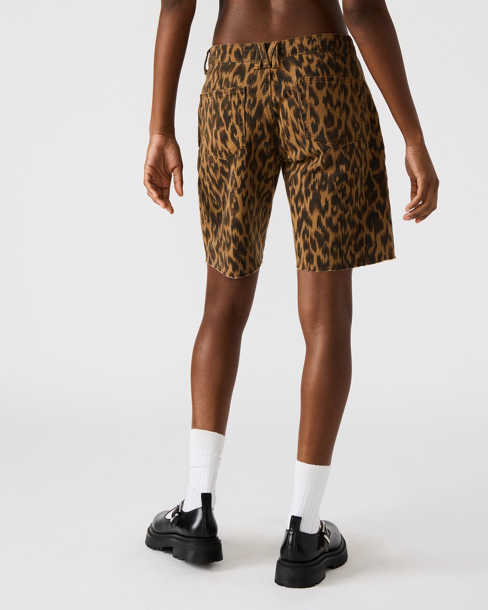 Model showcasing the functional pockets of MILLIE leopard print denim shorts.