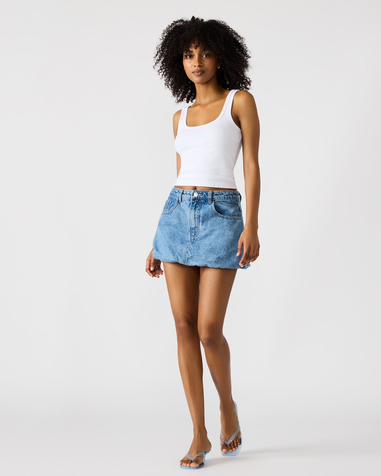 Close-up of the denim mini skirt with front pockets and zipper detail