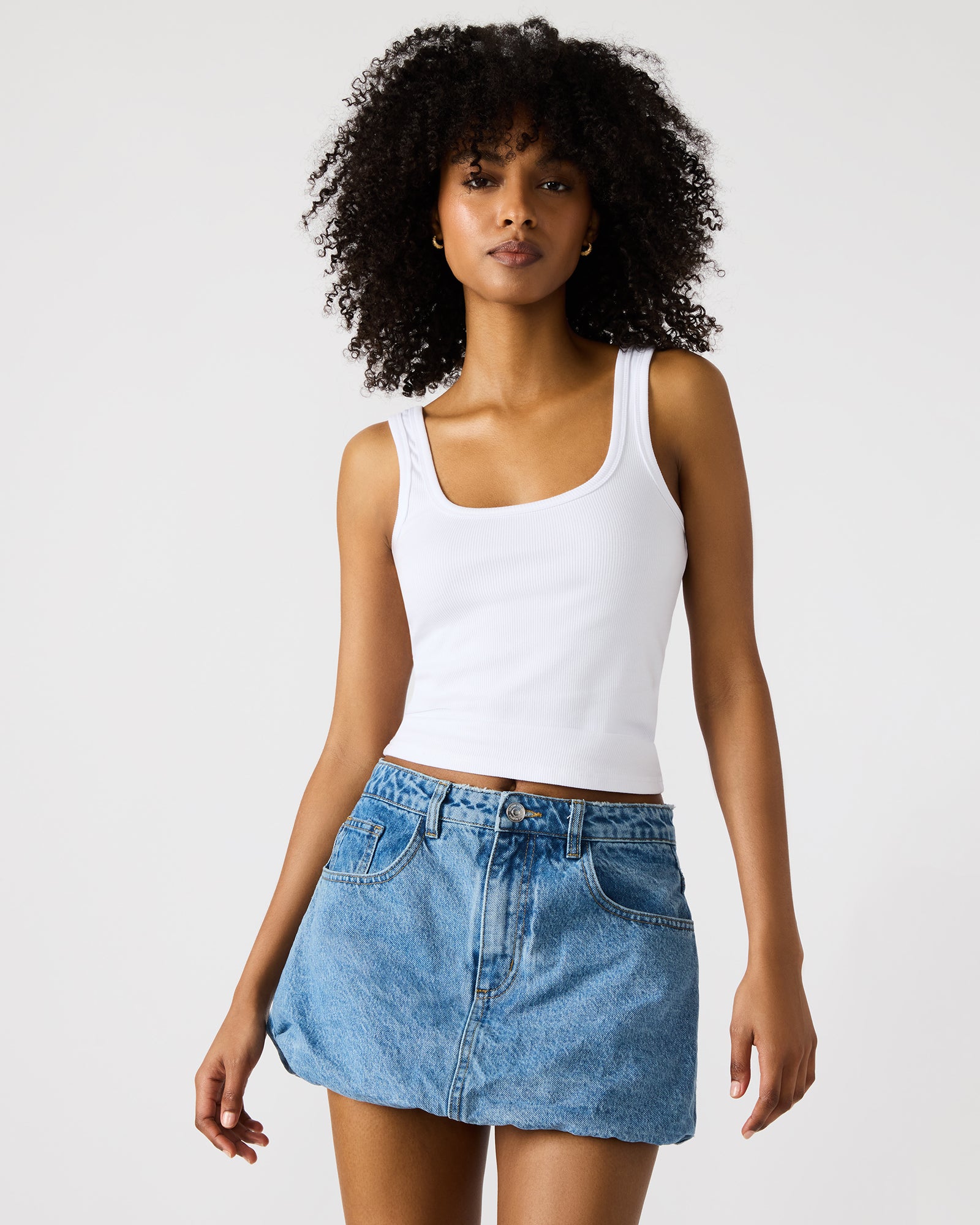 Model wearing the denim mini skirt paired with a white top