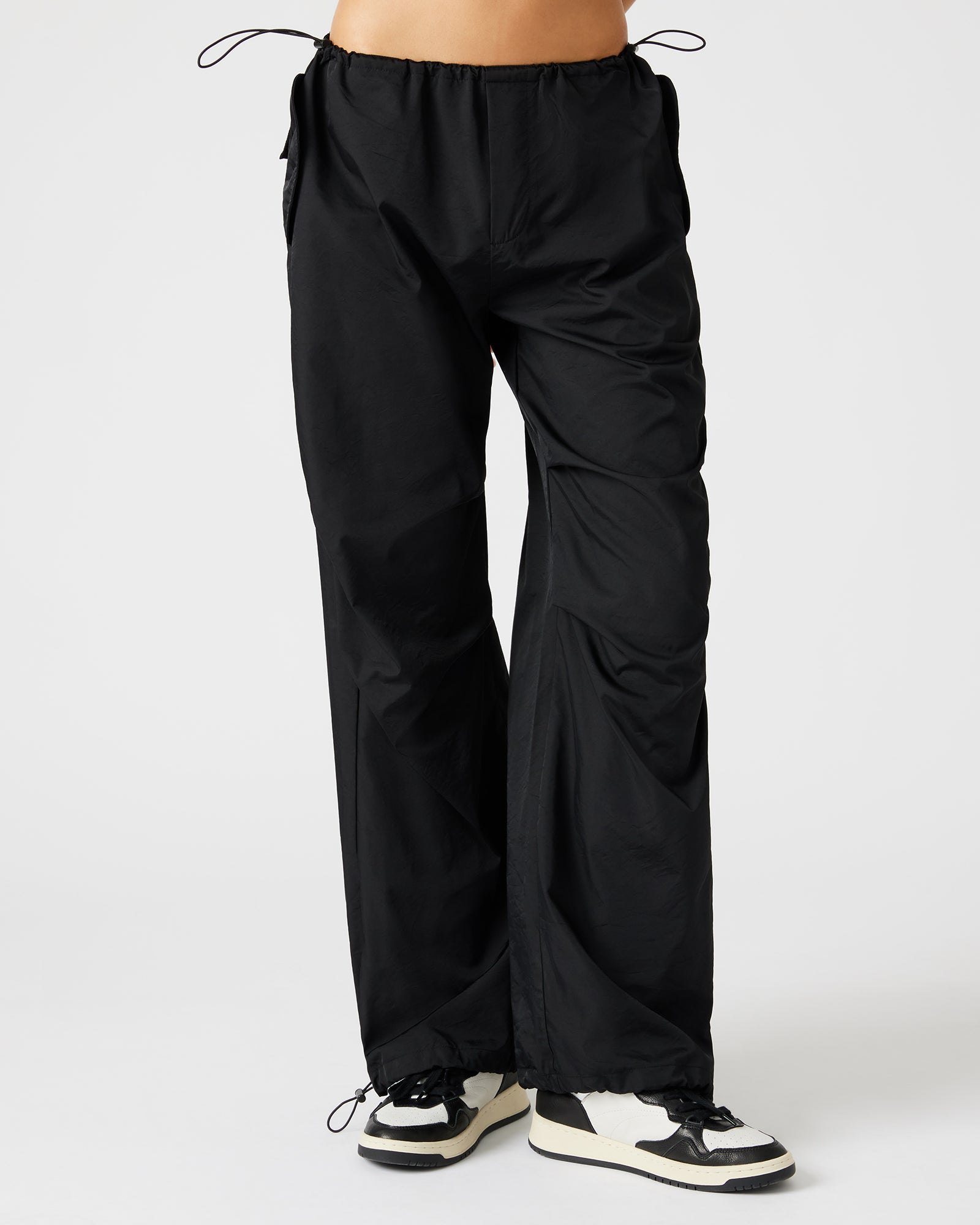 Side view of PIA parachute pants highlighting the adjustable drawstring feature.