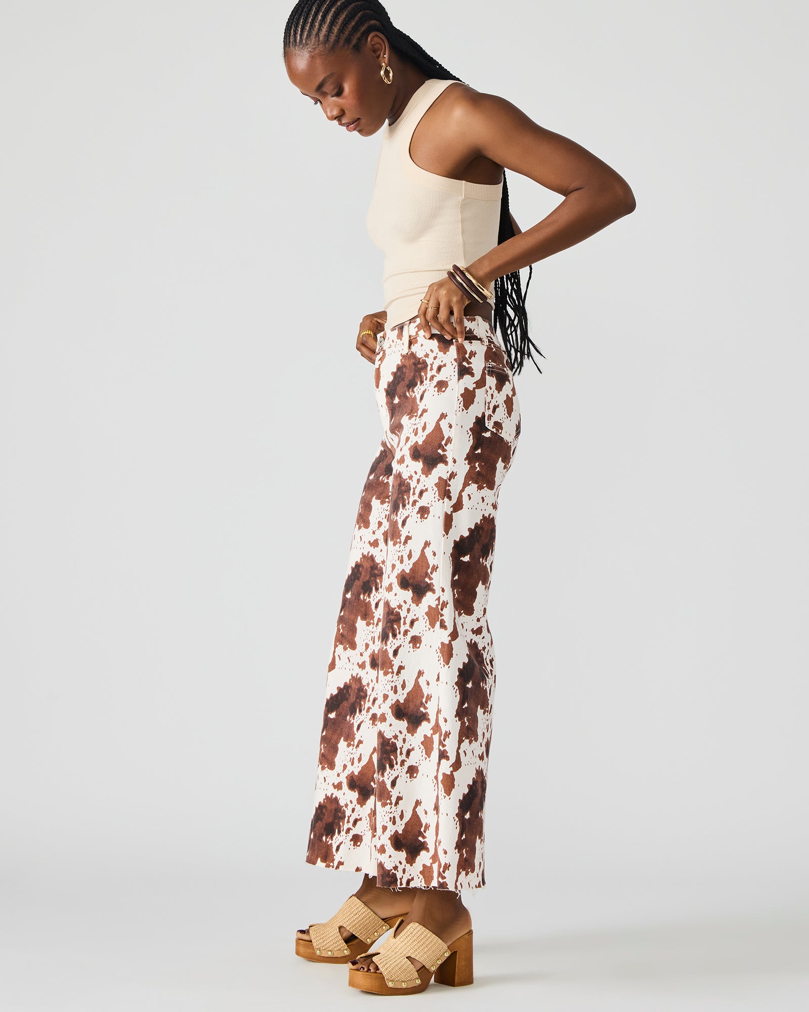 Side view of cow print jeans showing their stylish wide-leg design.