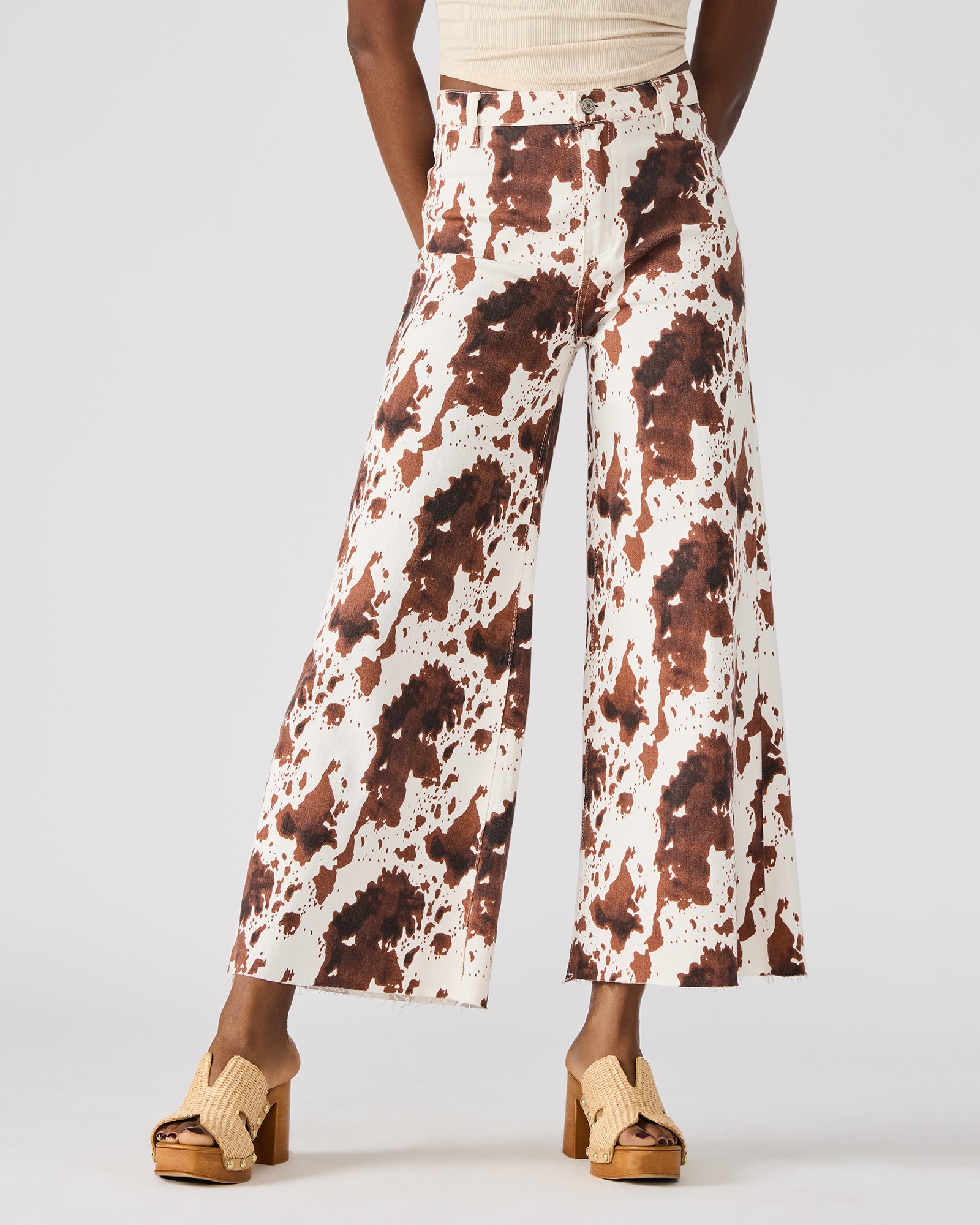 Side view of cow print jeans showing their stylish wide-leg design.