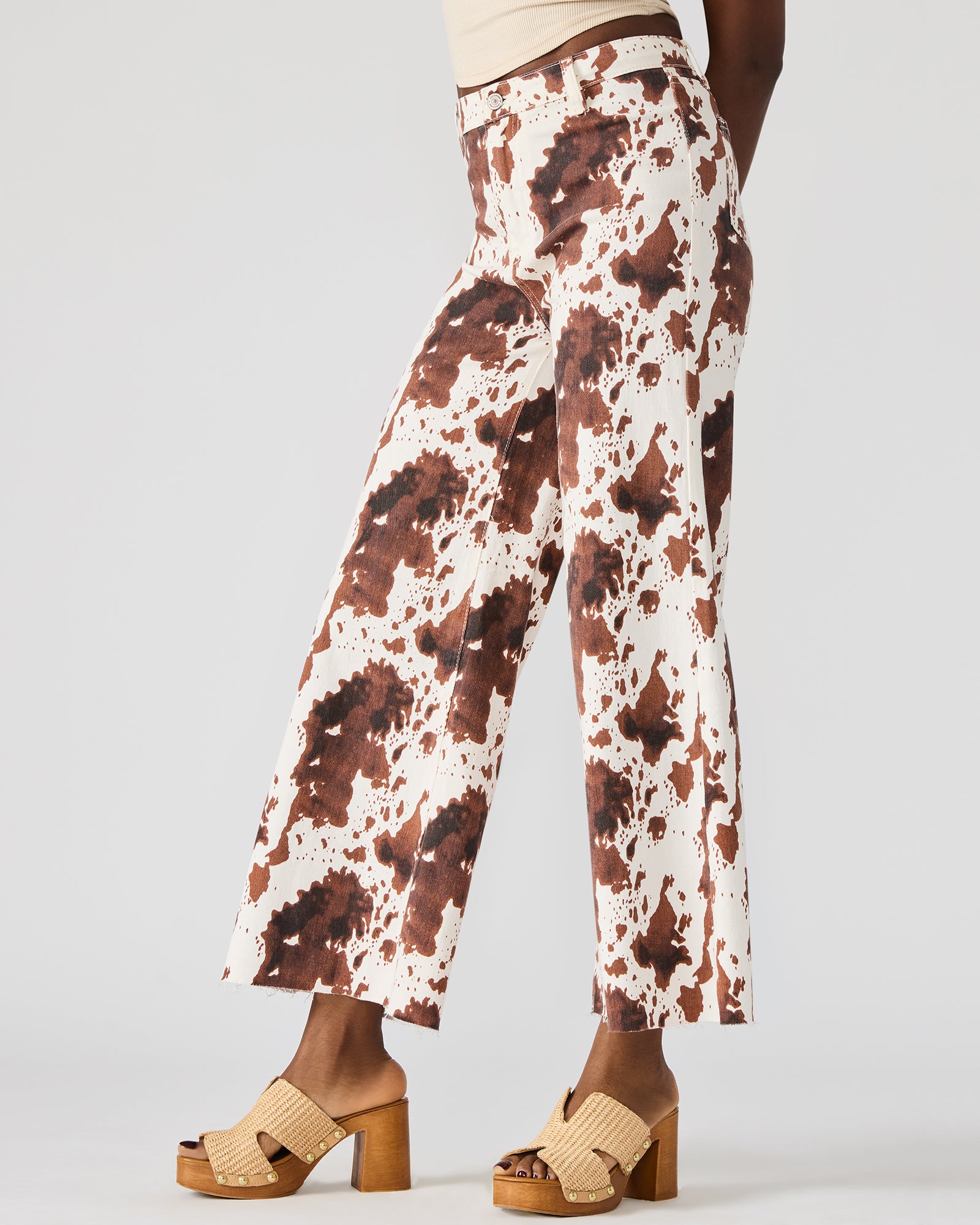Close-up of the cow print pattern and detailed button closure.