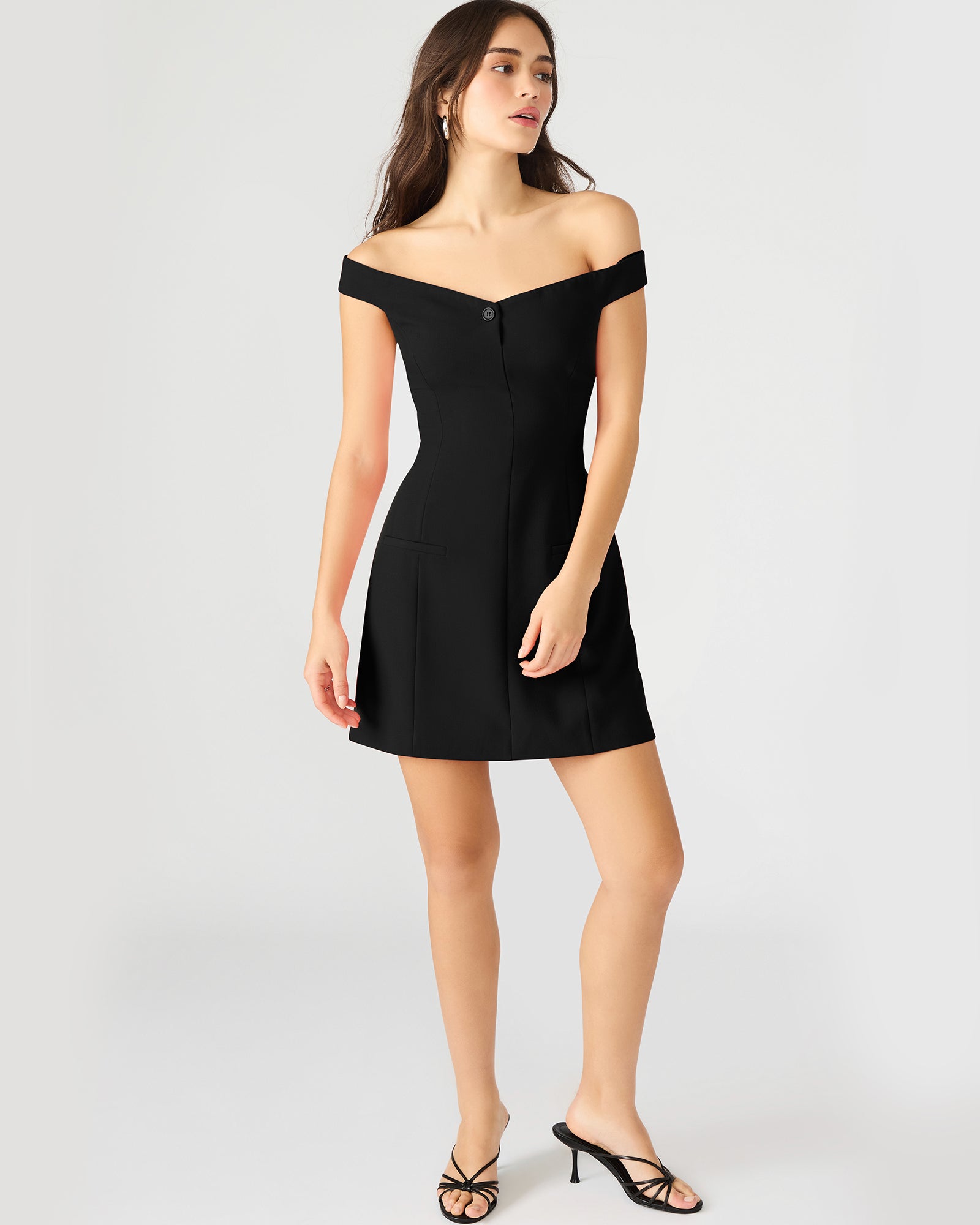 Front view of the black off-the-shoulder dress showcasing pleated design.