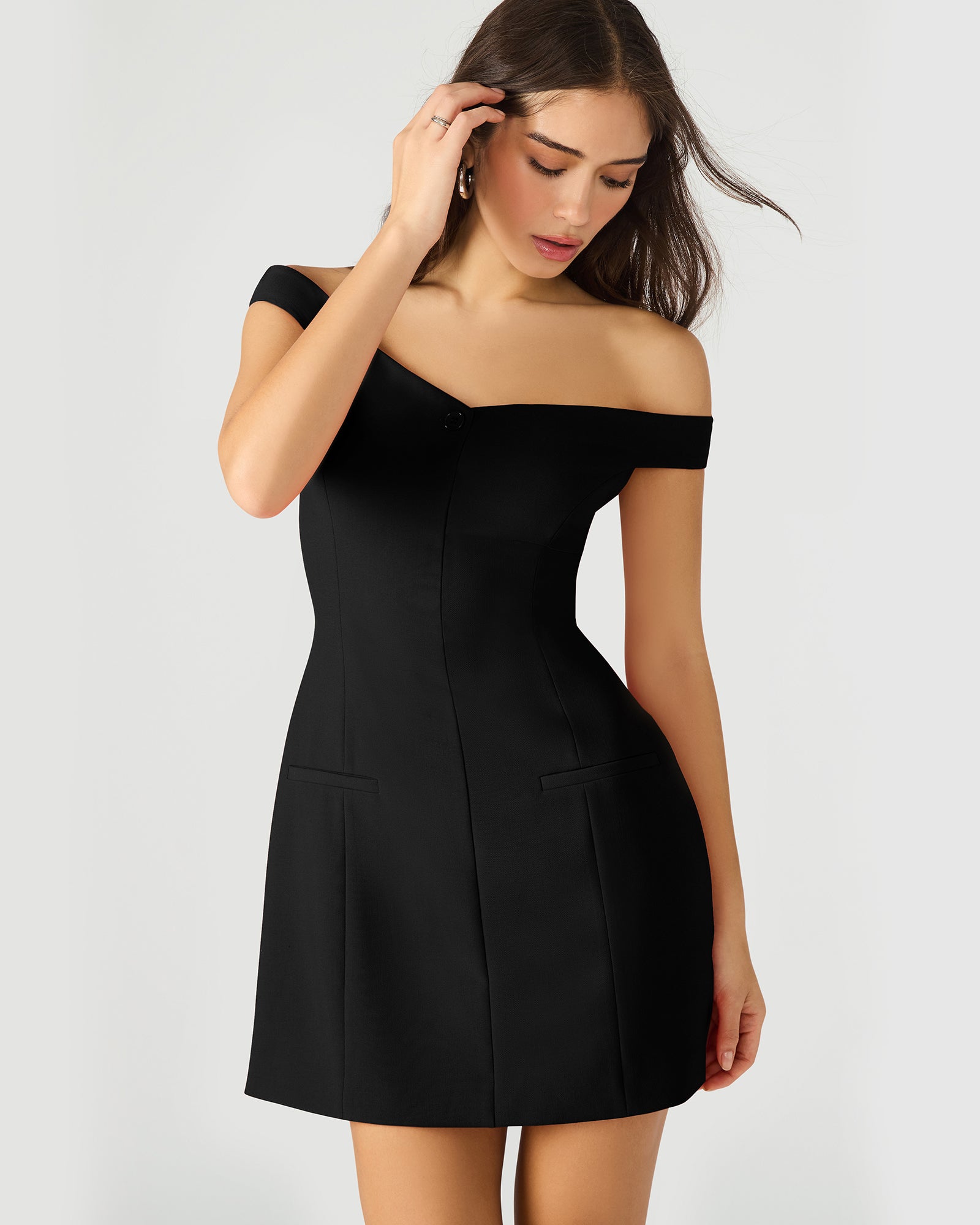 Side angle of the black long sleeve mini dress highlighting button details.