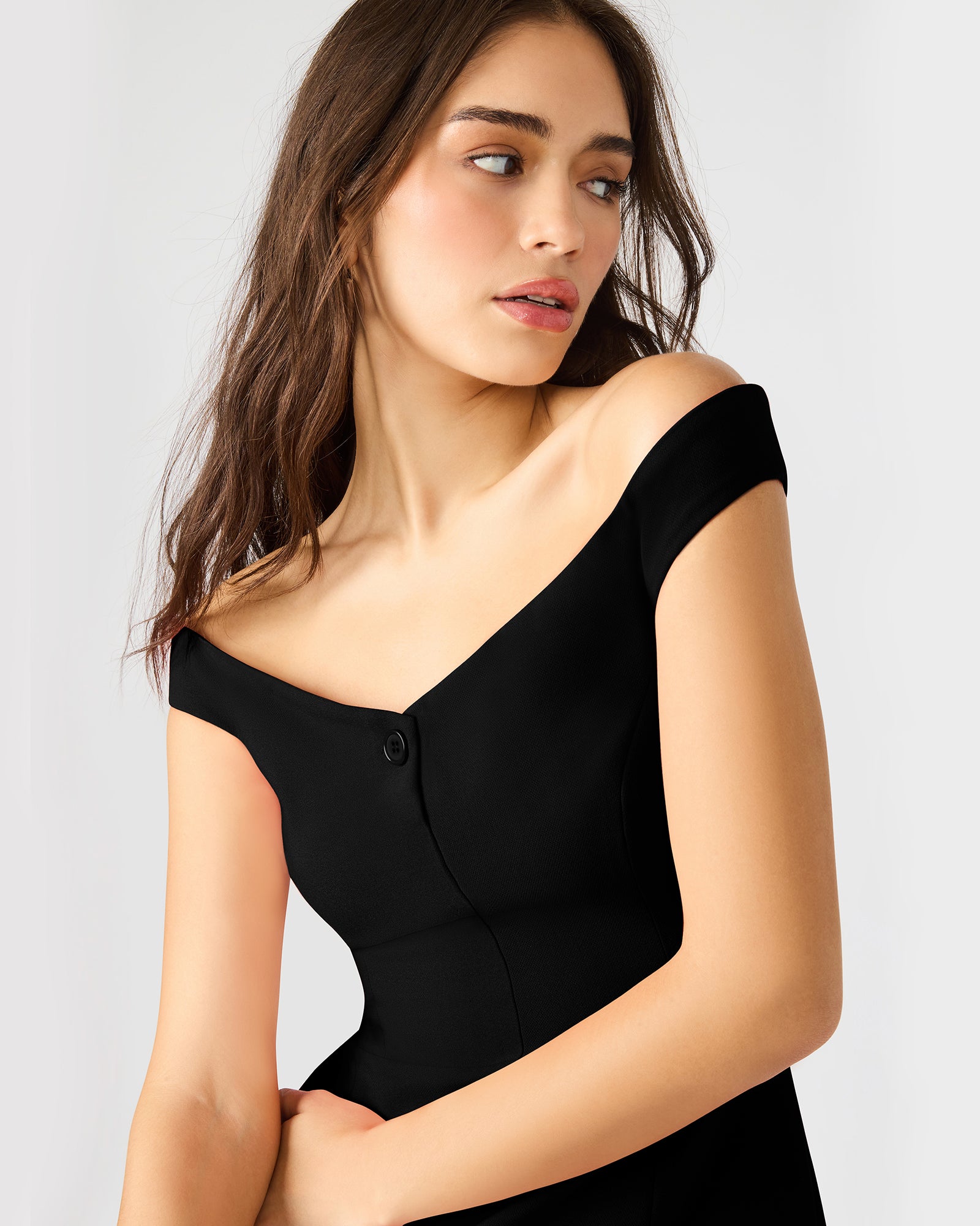 Side angle of the black long sleeve mini dress highlighting button details.