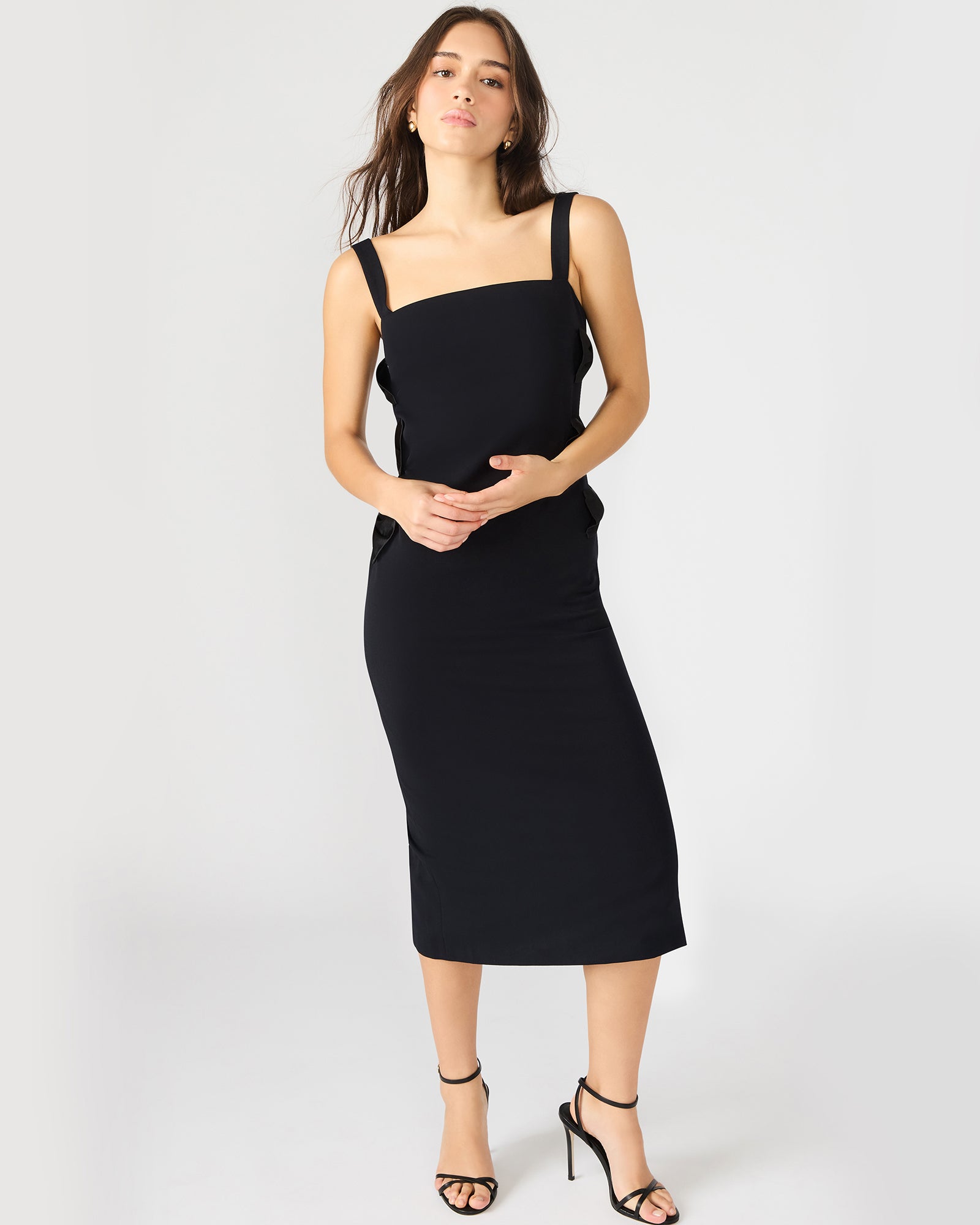 Side view showcasing the form-fitting silhouette of this black long sleeve midi dress