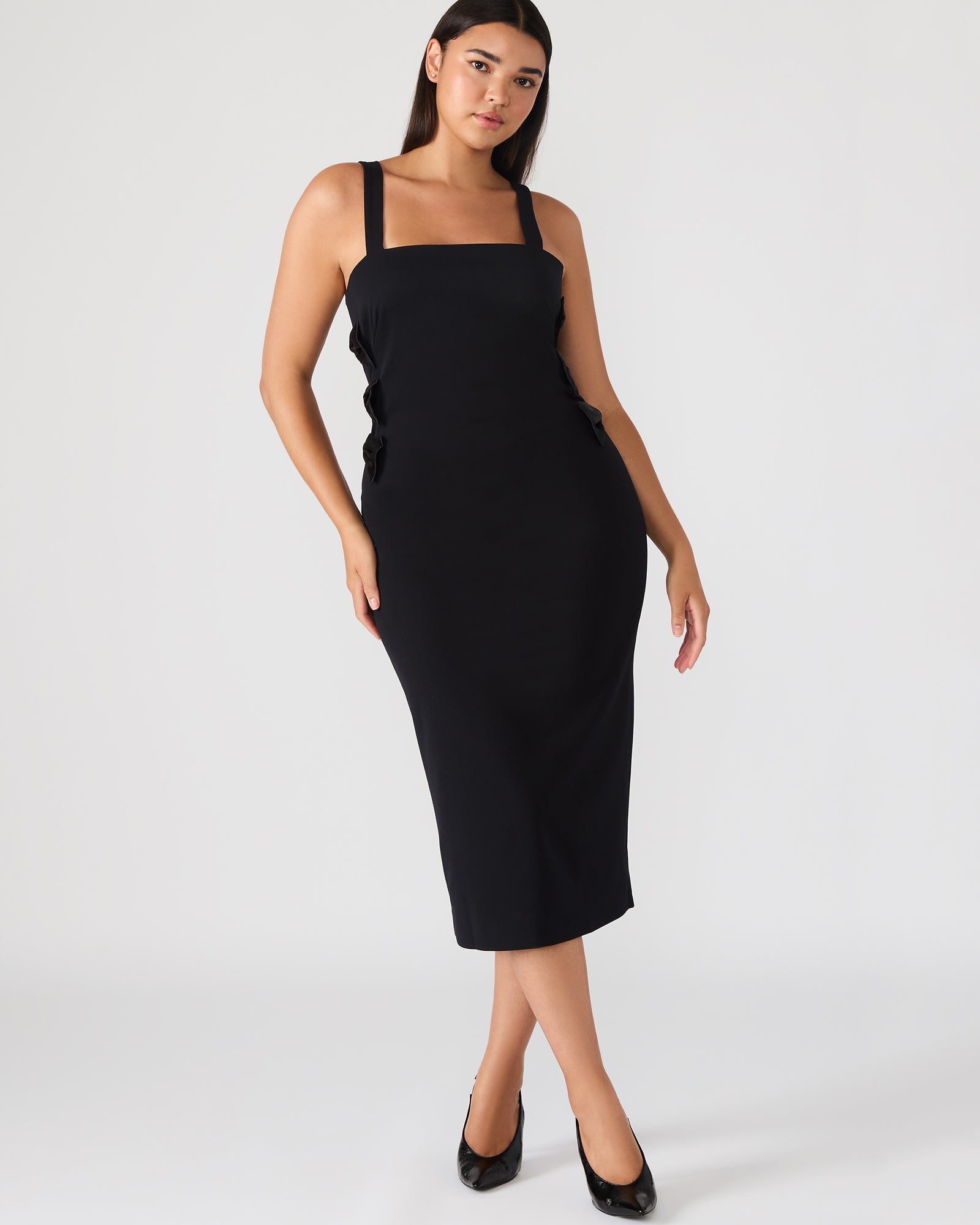 Close-up of the black midi dress’s cut-out detailing and bow embellishments