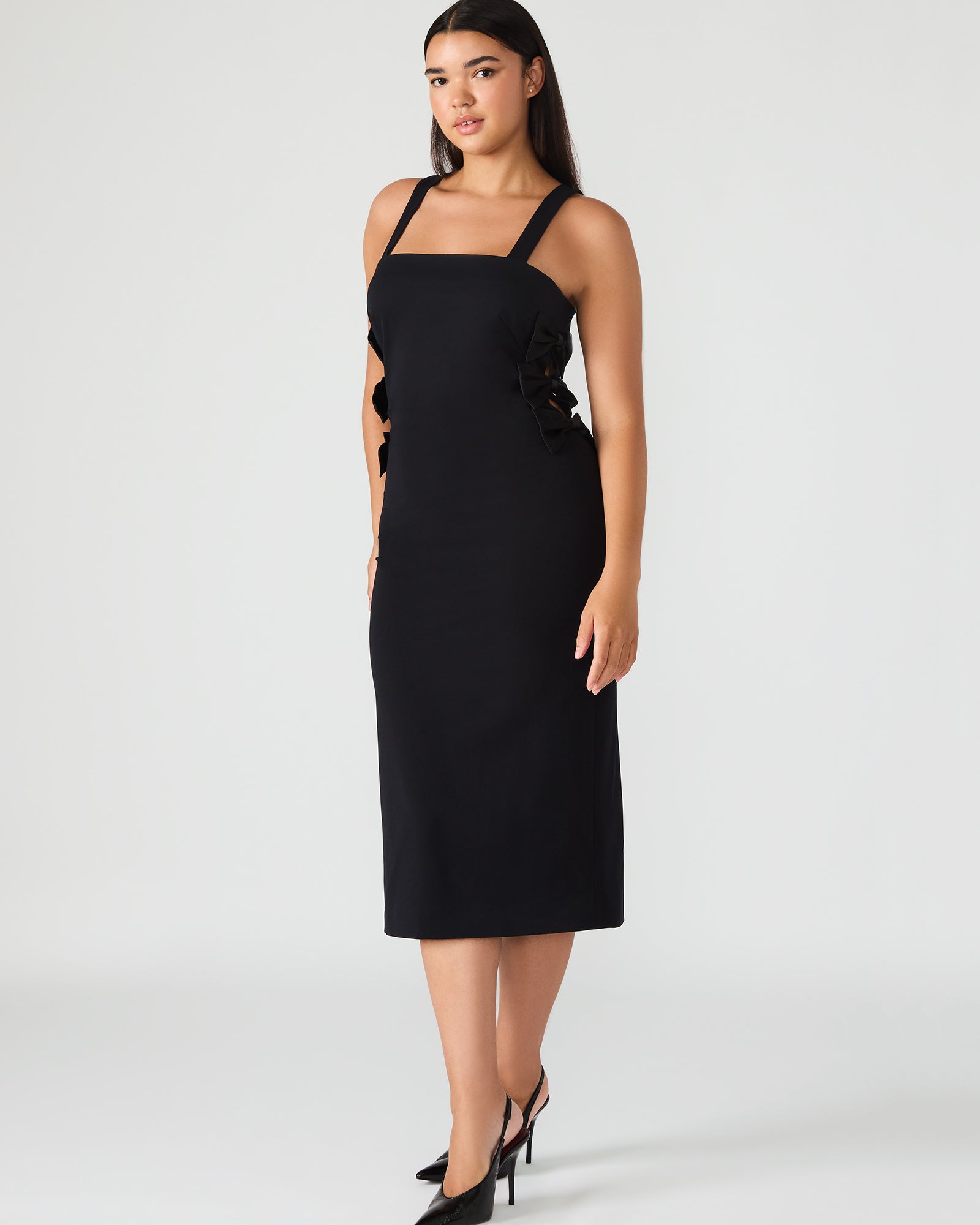 Side view showcasing the form-fitting silhouette of this black long sleeve midi dress