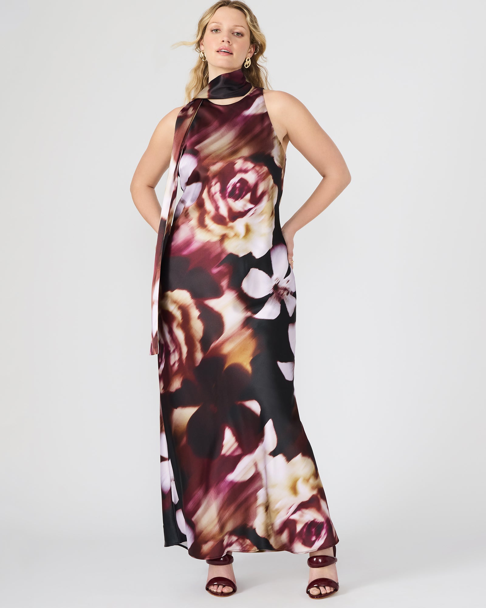 Woman wearing a pink floral maxi dress in a summer garden