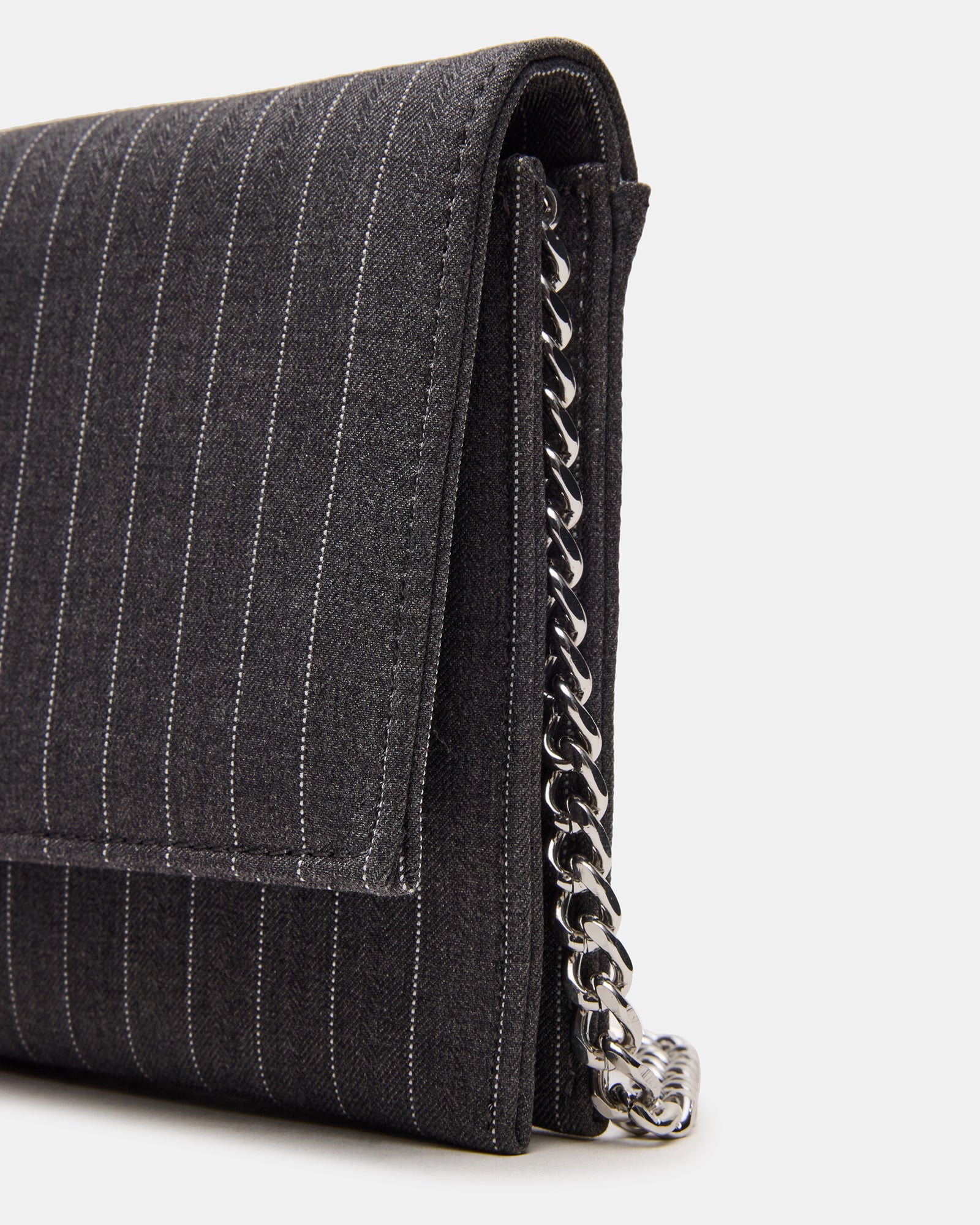 Juliana black crossbody bag placed on a marble counter beside sunglasses