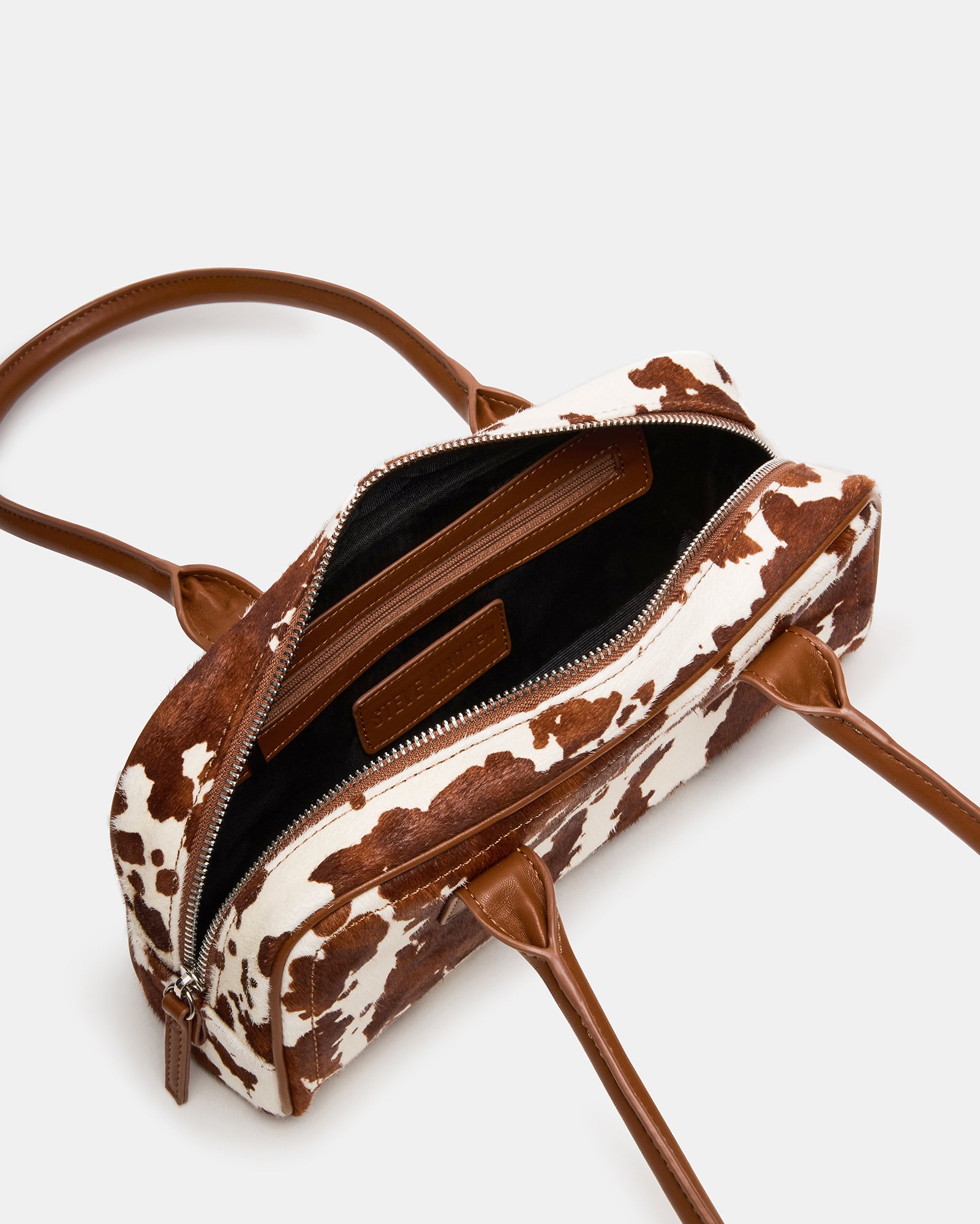Interior of the cow print tote showing organized pouch compartments