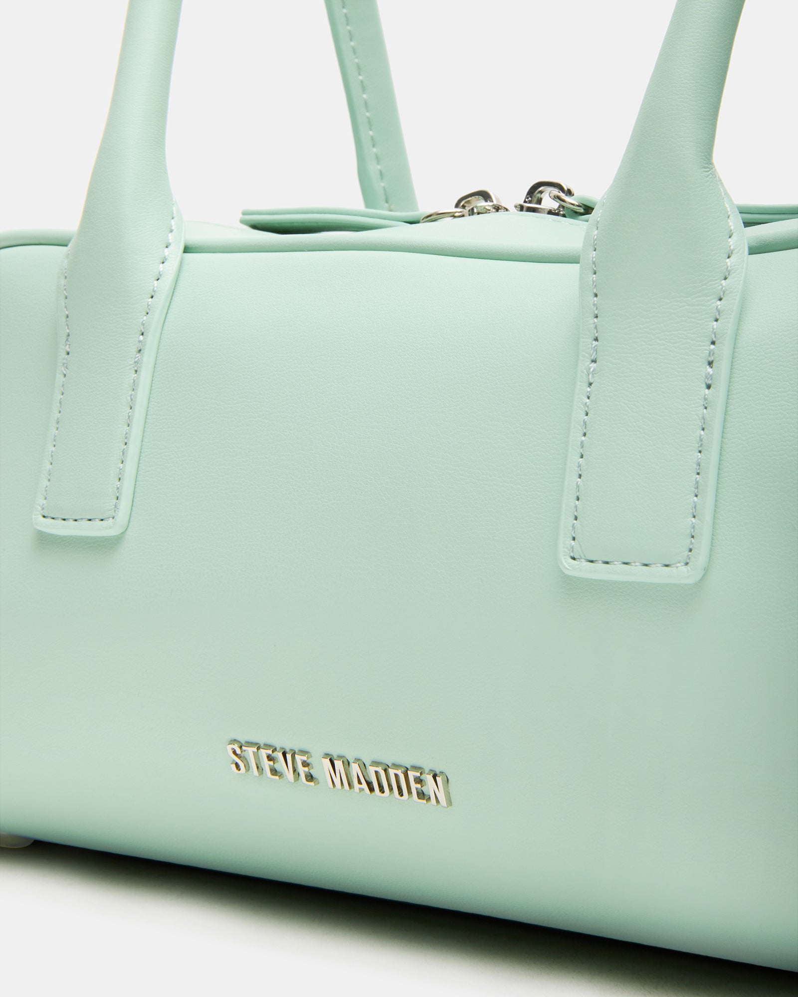 Pistachio shoulder bag styled with casual outfit in a chic urban setting.