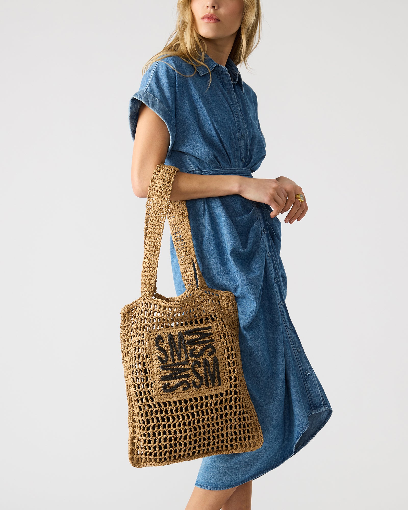Side angle of the woven leather tote handbag with drawstring pouch inside.
