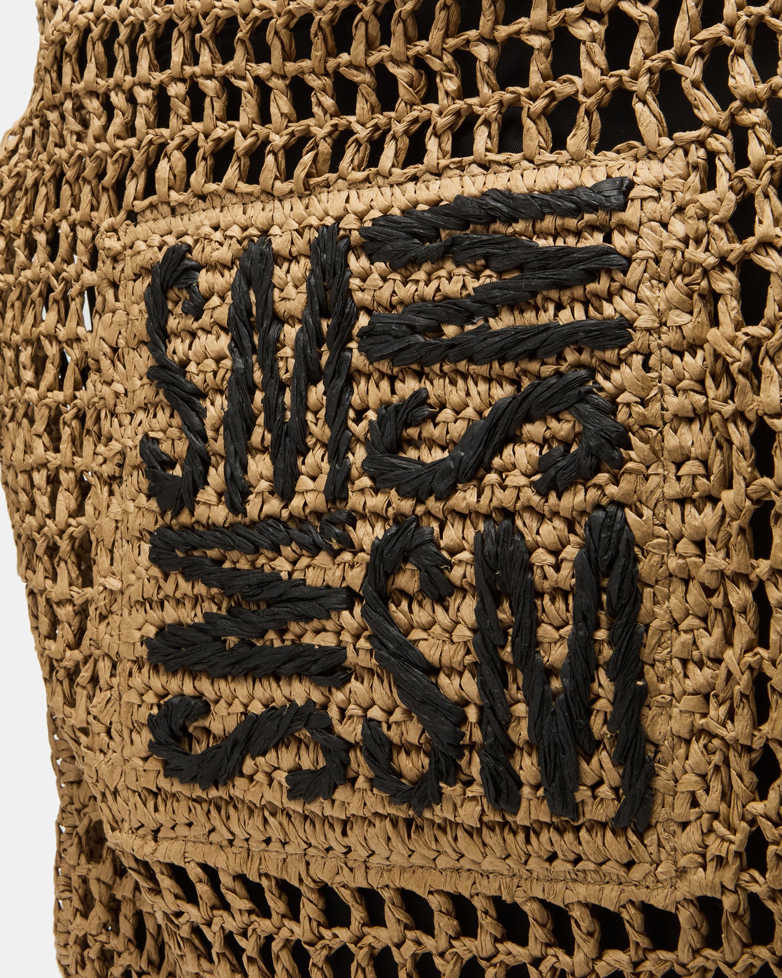 Close-up of the interior of the woven handbag, highlighting the drawstring pouch.