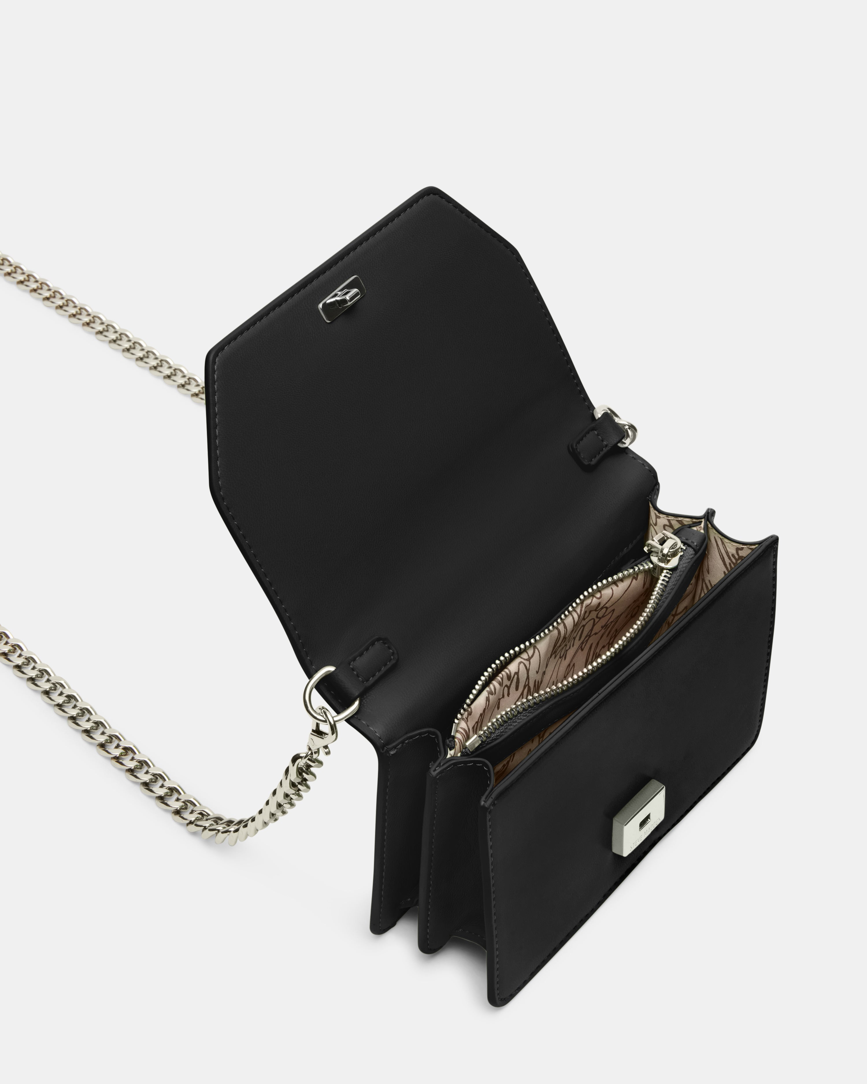 Close-up of the top handle on the black crossbody bag.
