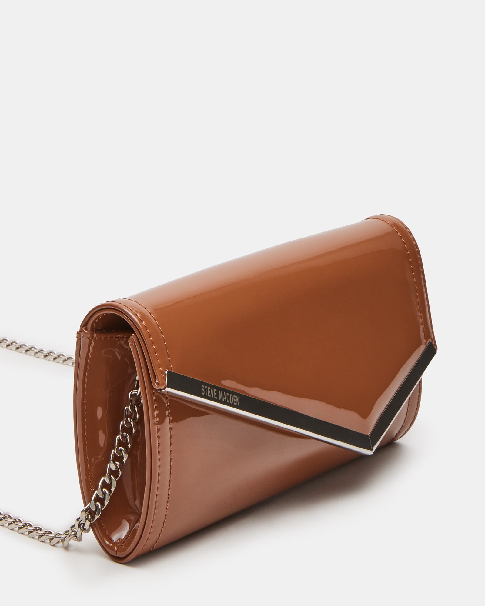 Close-up of tan patent leather clutch bag showing asymmetrical flap detail