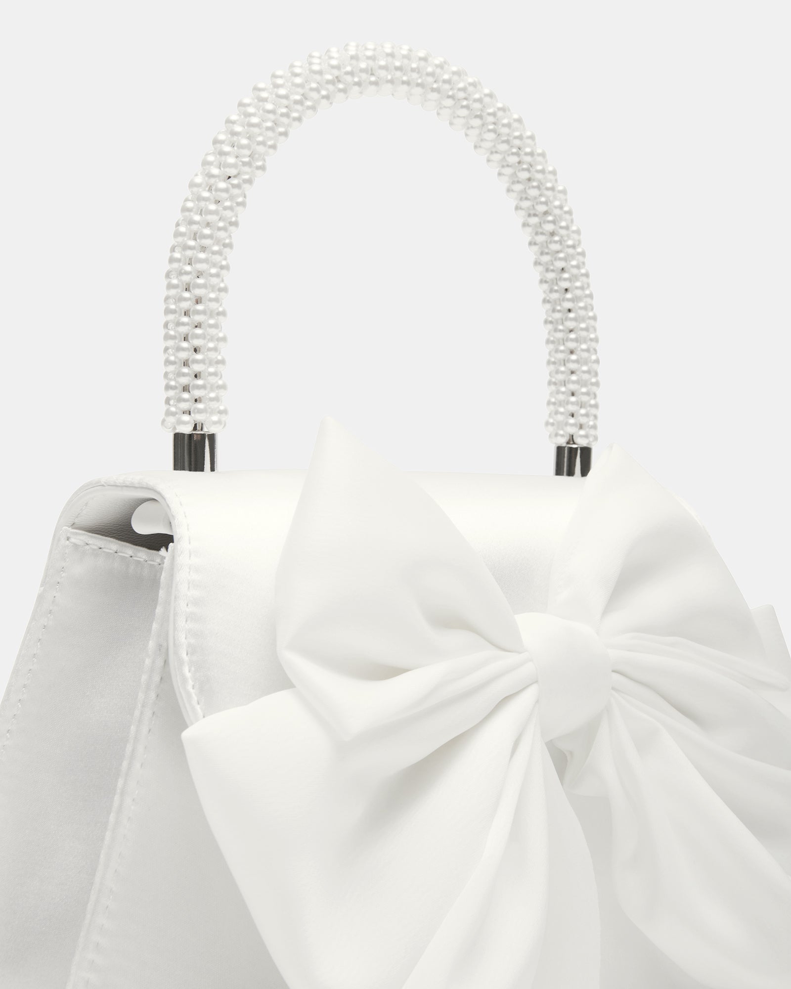 Close-up of silver evening clutch bag with satin bow.