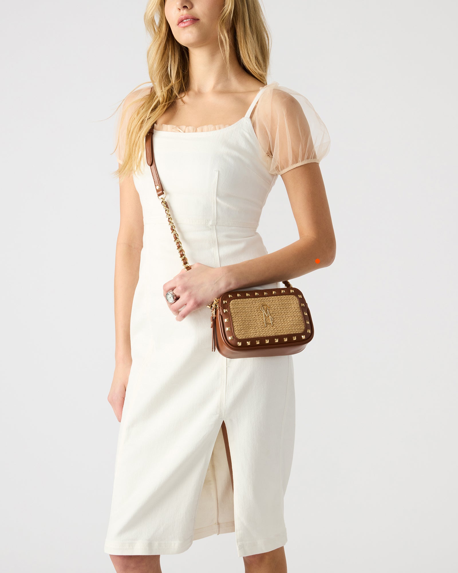 Model carrying the straw crossbody bag during a daytime outing