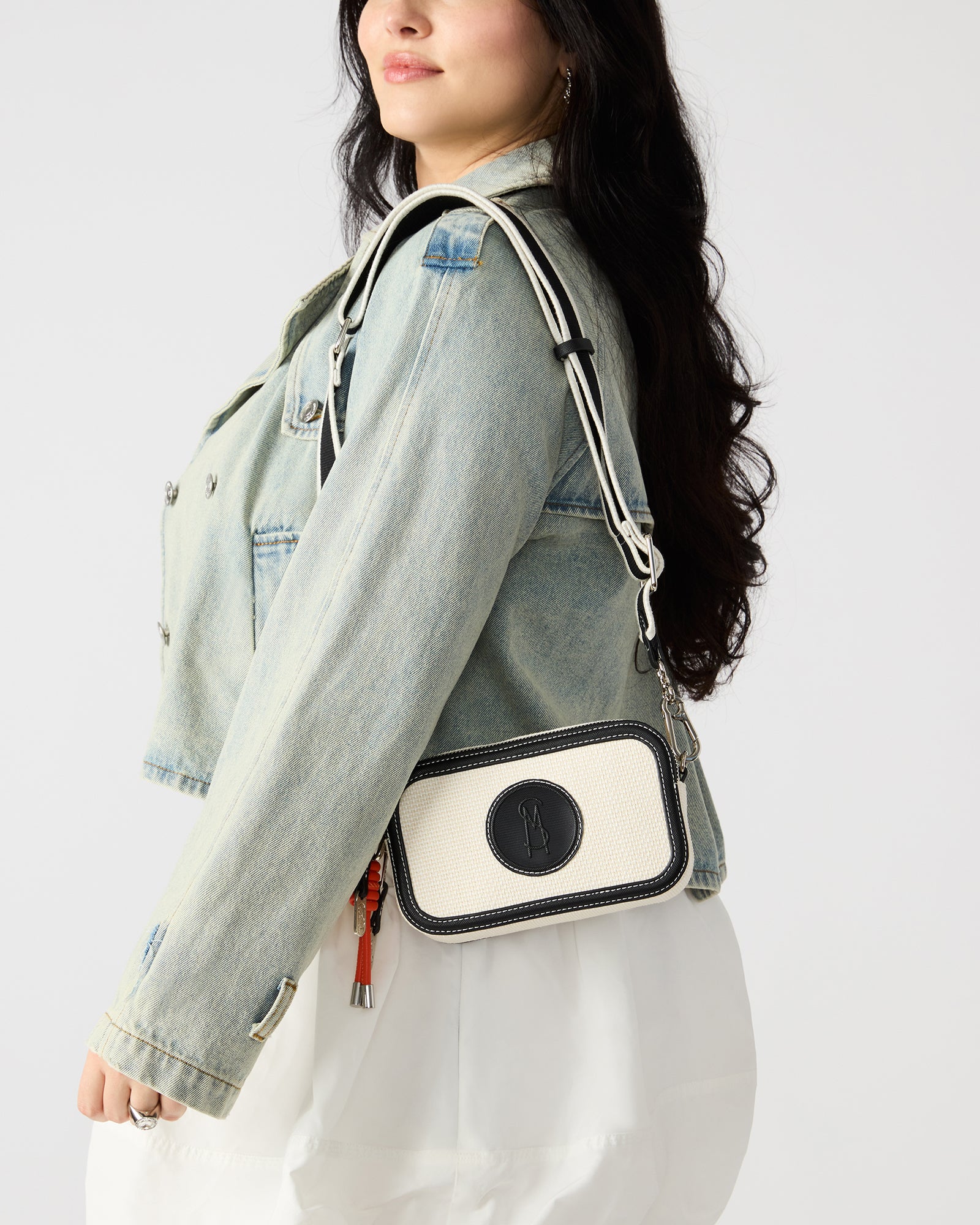 Front view of the Derrick black crossbody bag showcasing the logo patch.