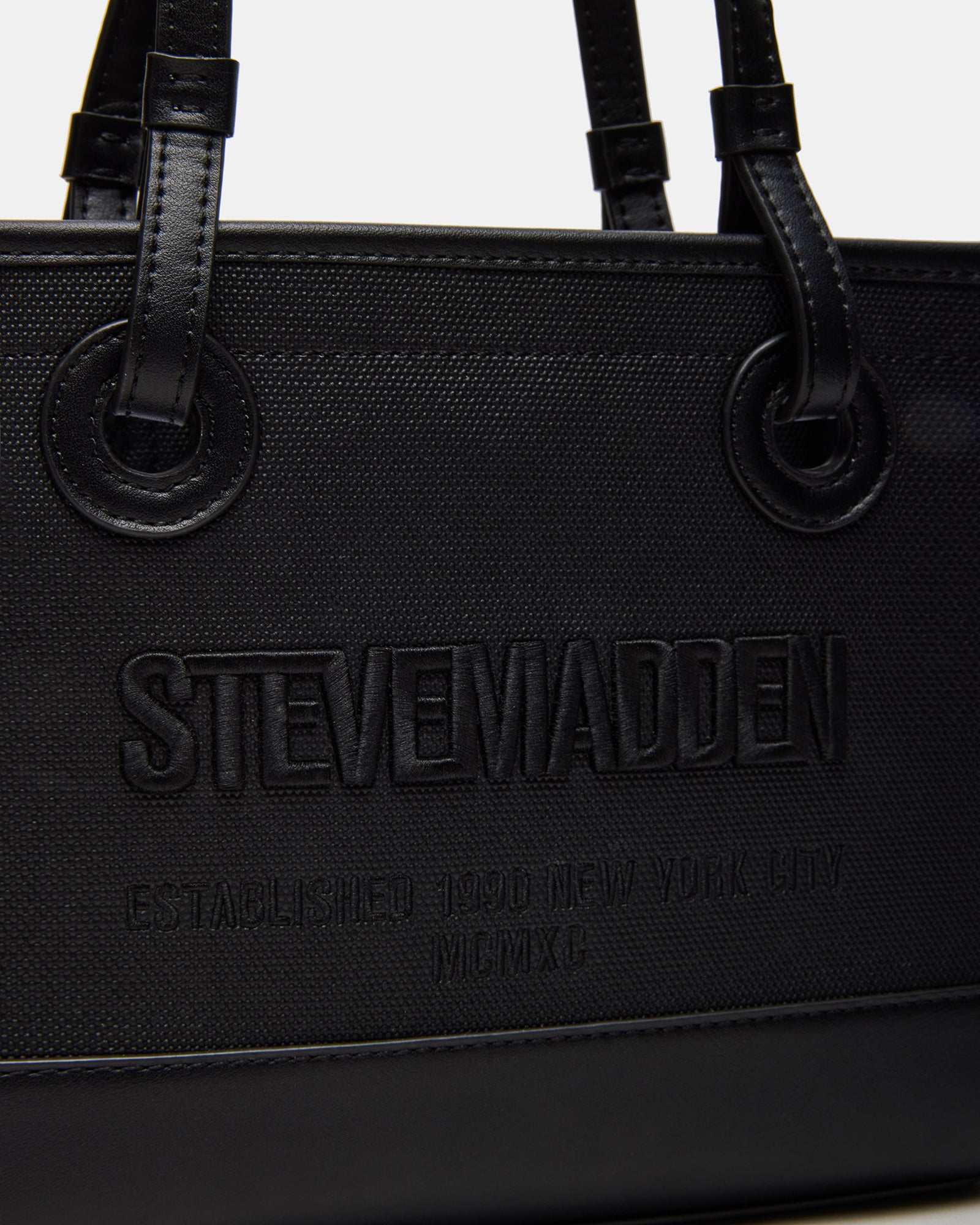 Bag shown with detachable strap on a wooden table