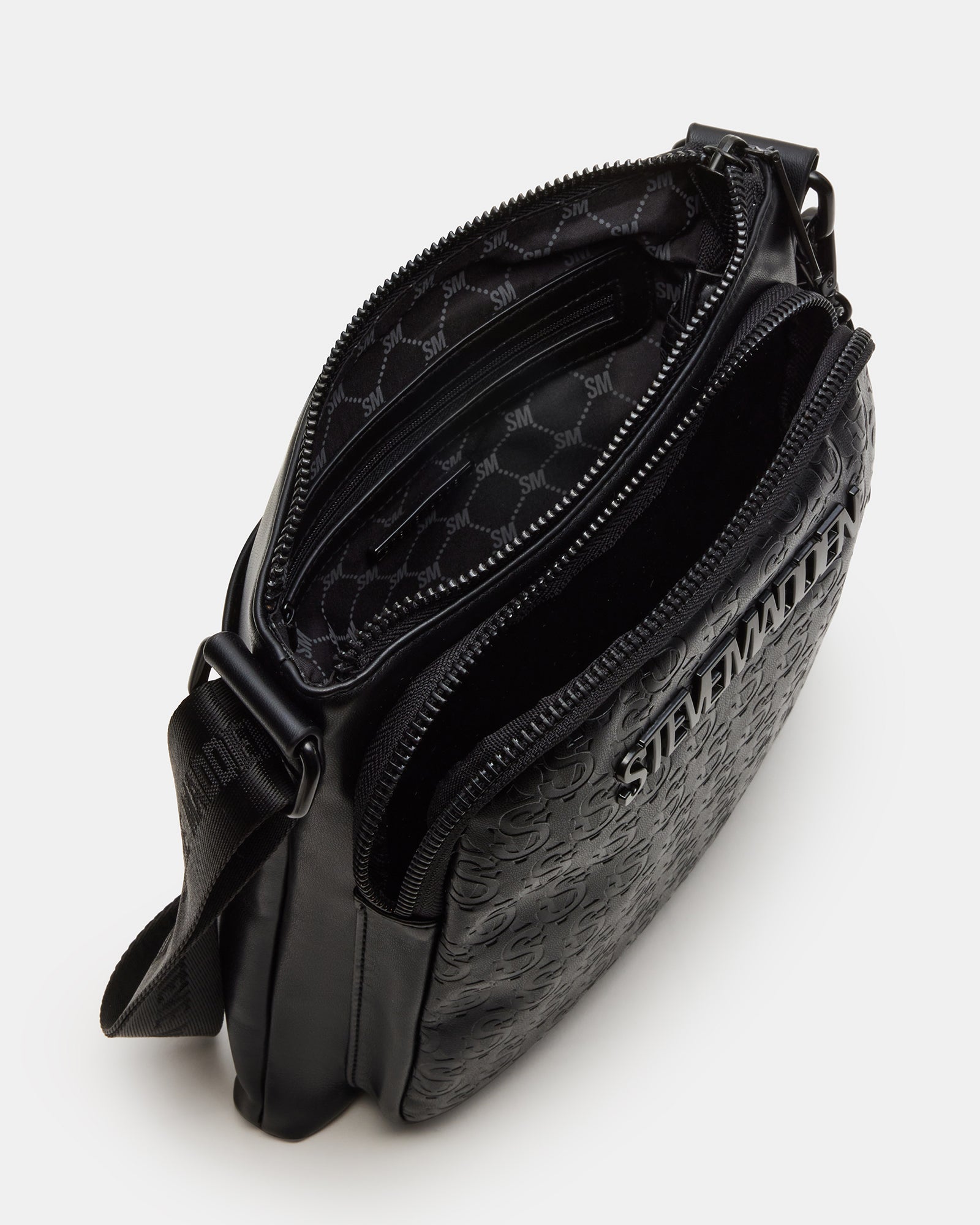Close-up of the black leather crossbody bag with tassel charm and logo detail