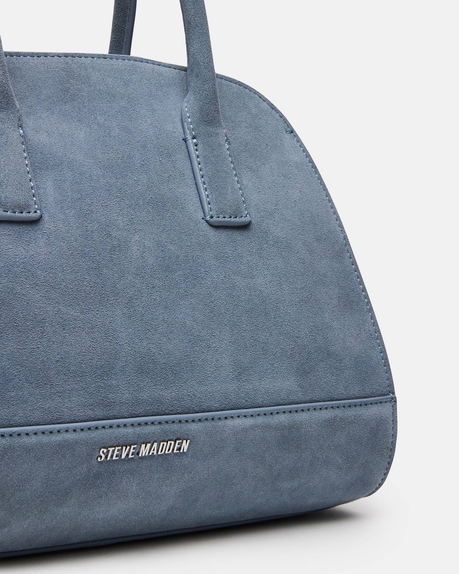 Luxury suede tote packed with essentials on boutique counter