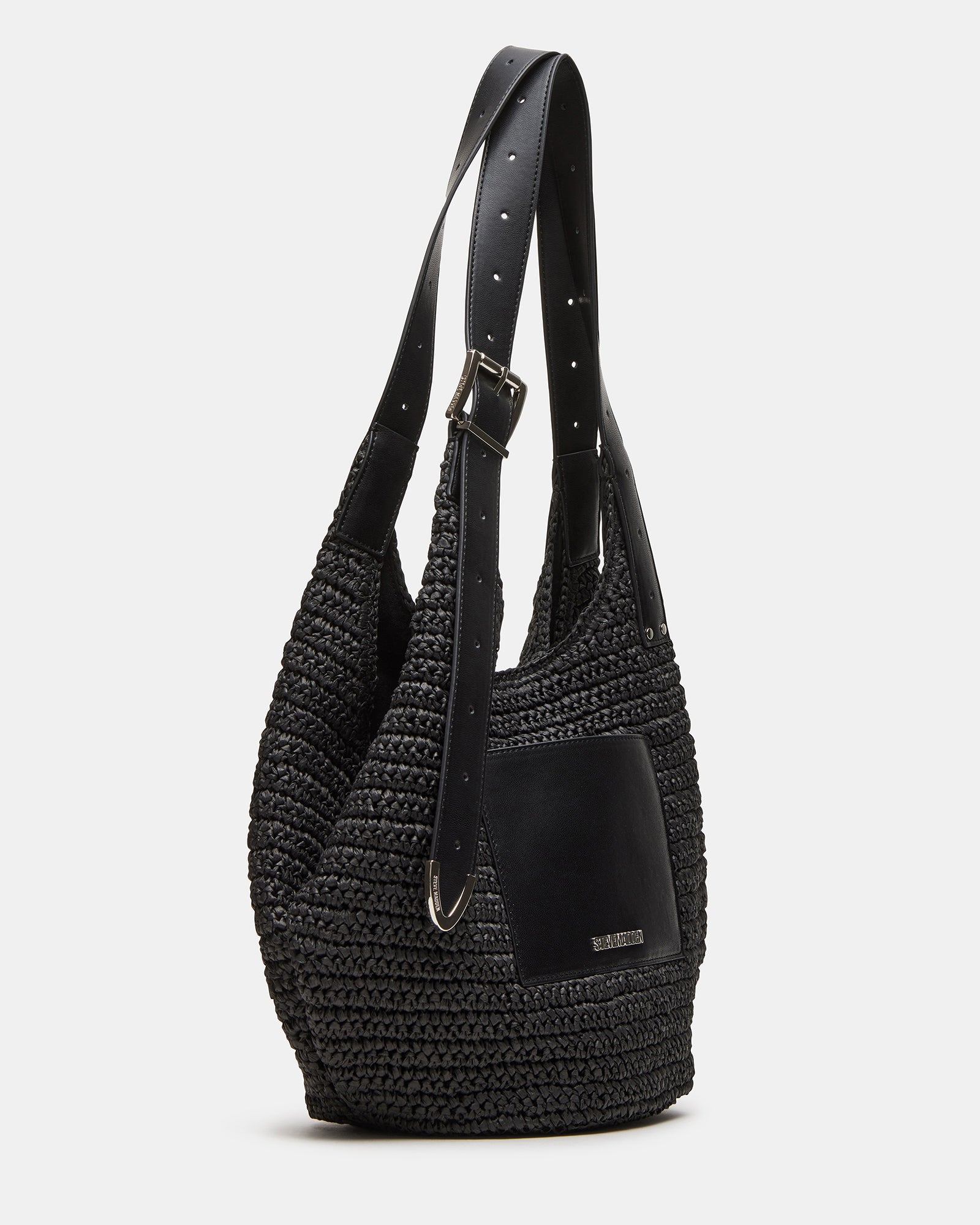 Close-up of the black leather shoulder bag showing straw panel and roller buckle strap detail