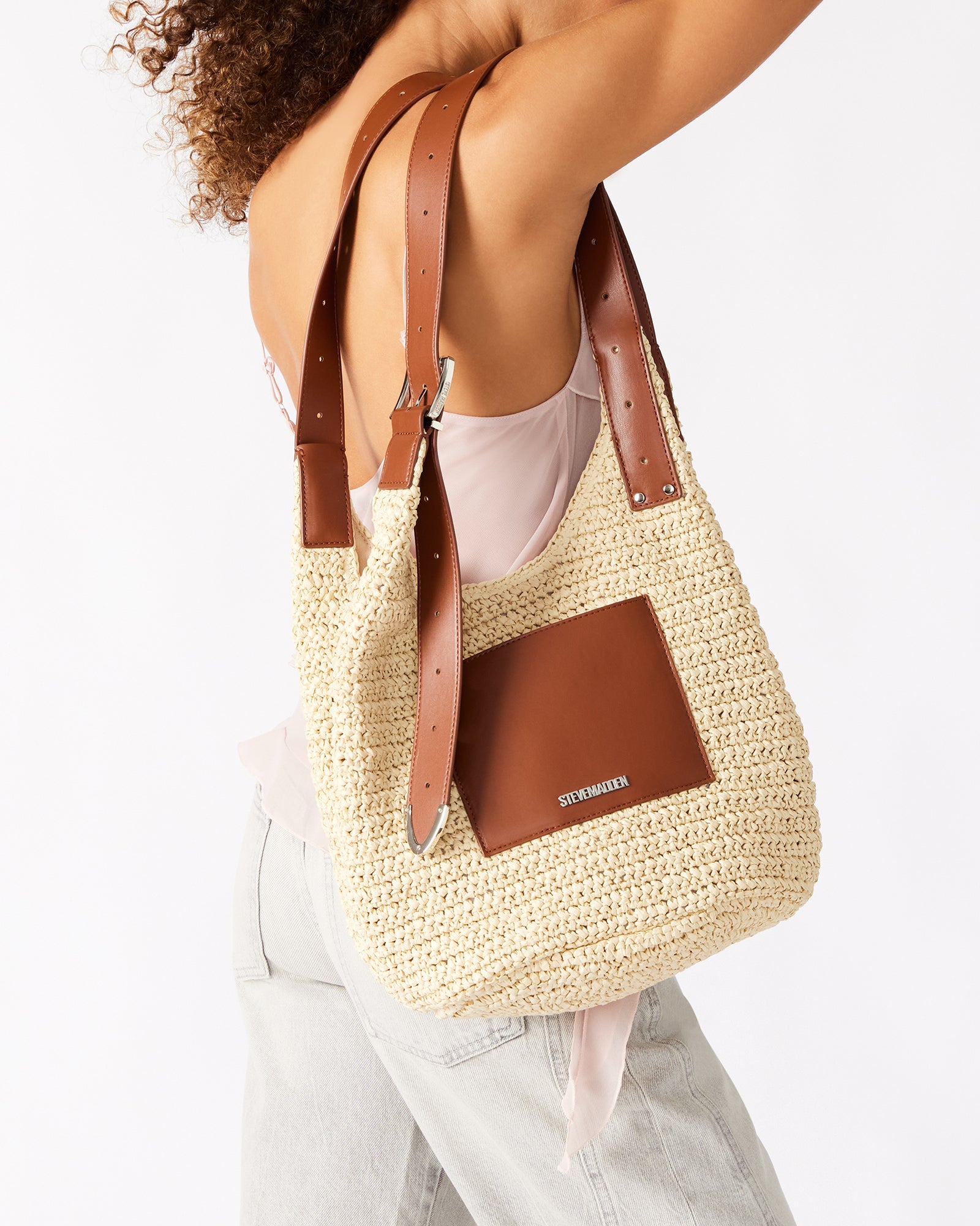 Close-up of the mag snap closure on the straw shoulder bag