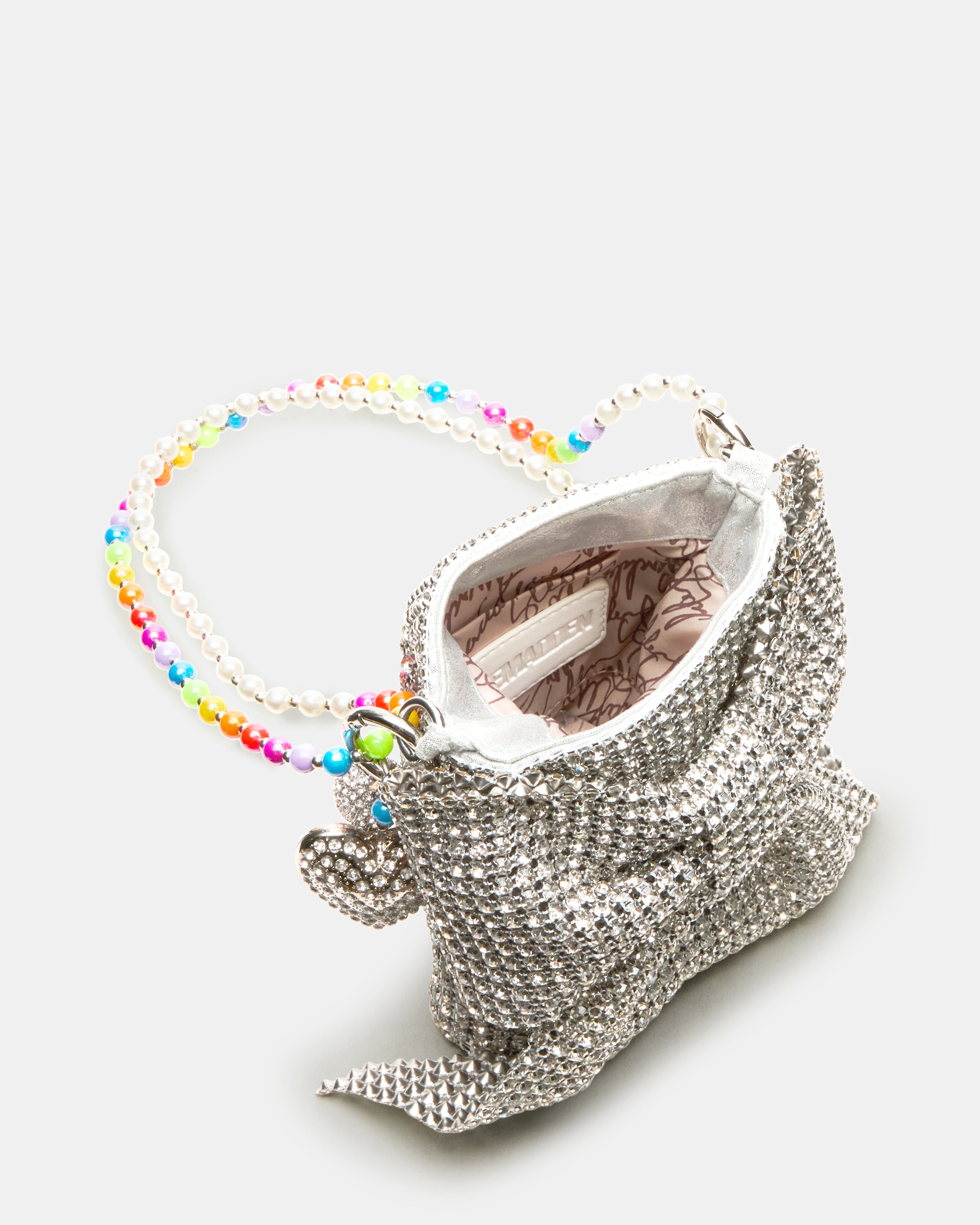 Model showcasing the bow-shaped rhinestone crossbody bag at a trendy café.