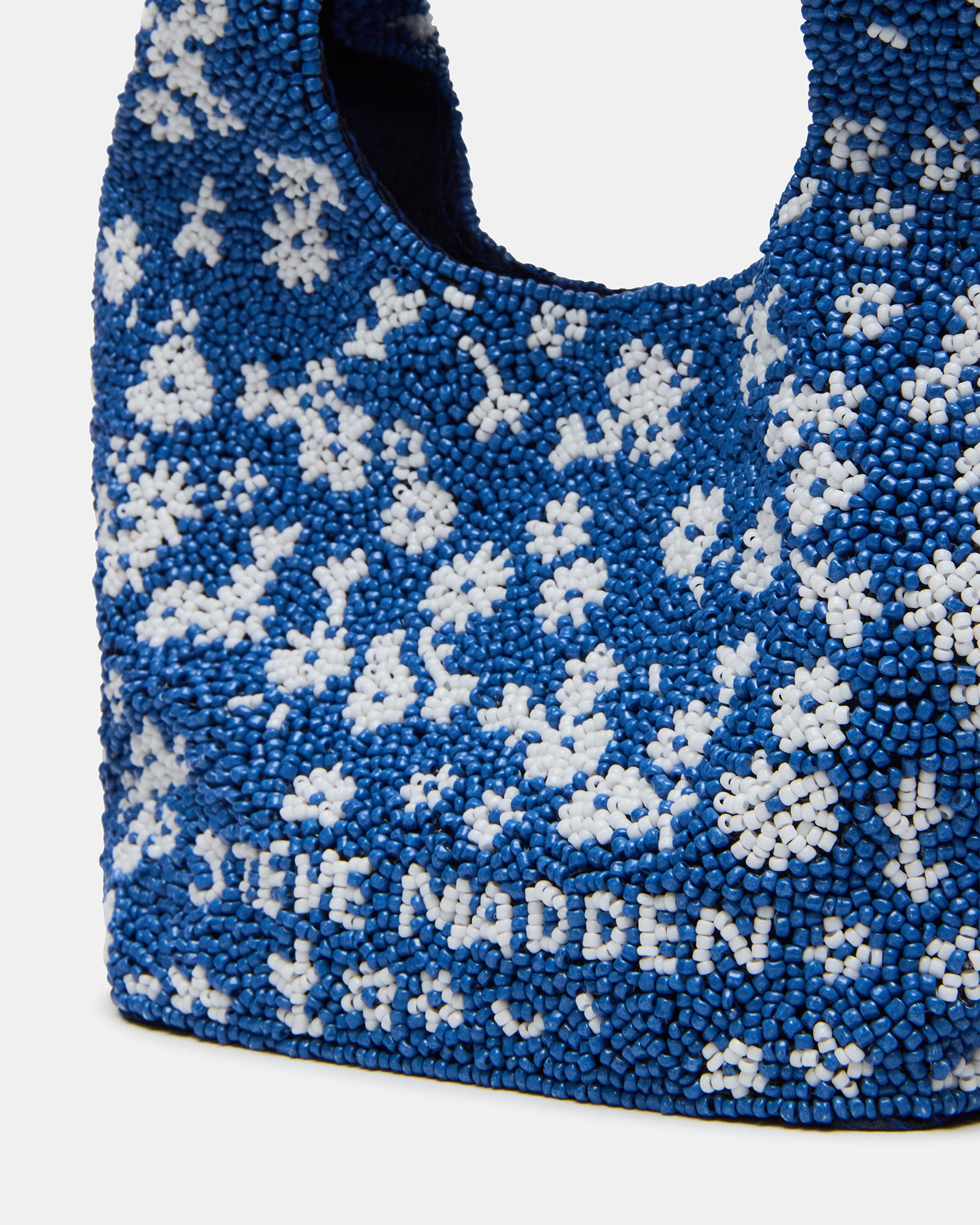 Model carrying the blue multi beaded mini bag crossbody in a city setting