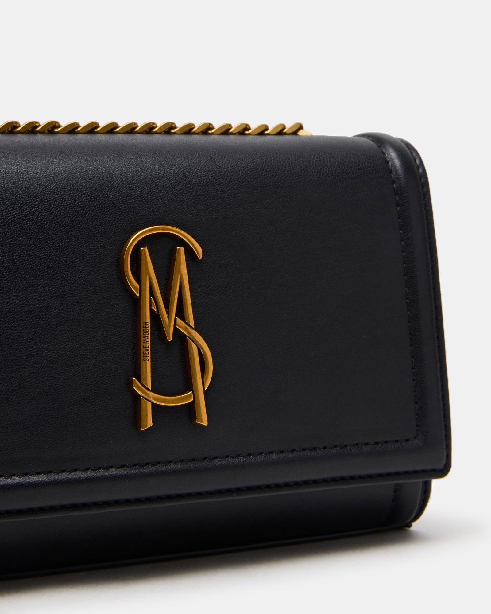 Small crossbody bag packed with essentials like phone and wallet, laid flat.