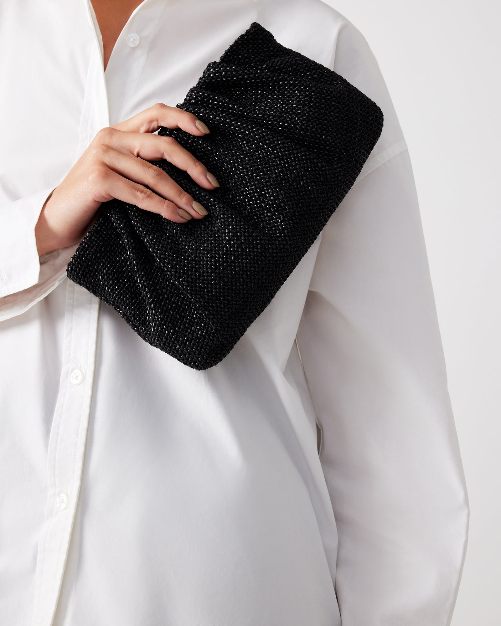 Chic Lucia raffia clutch bag in black, showcasing its pleated design.