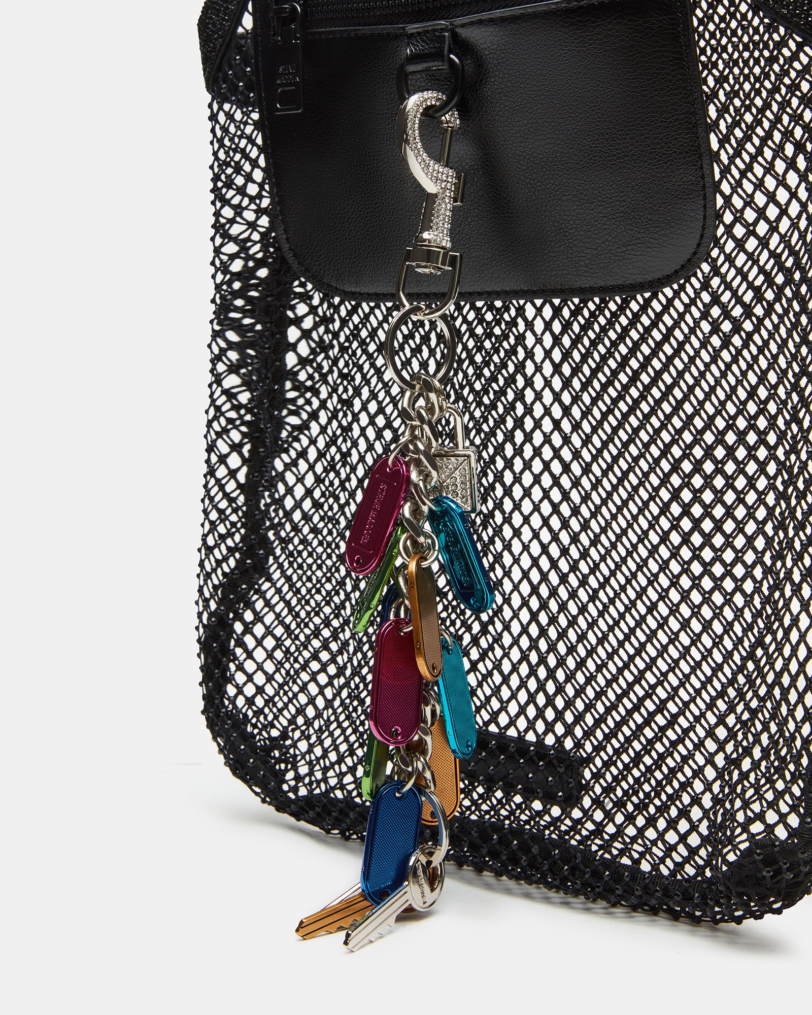 Close-up of the rhinestone shoulder strap on a black tote bag with chain charm.
