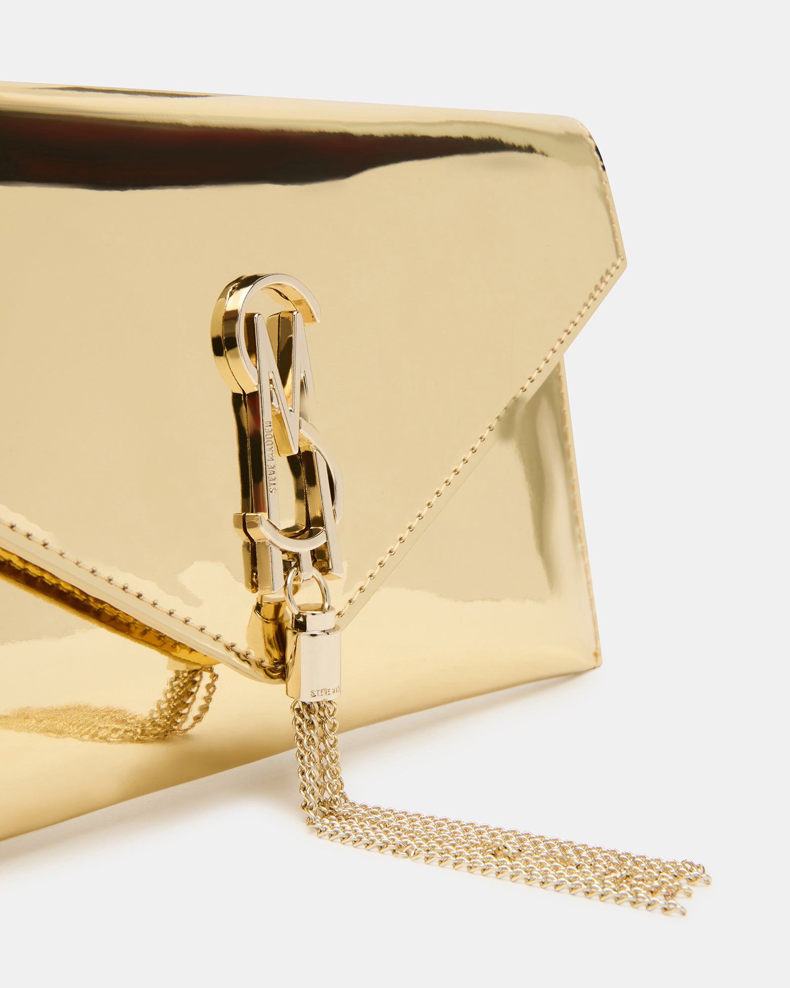 Side profile of clutch worn with crossbody strap in a city evening setting