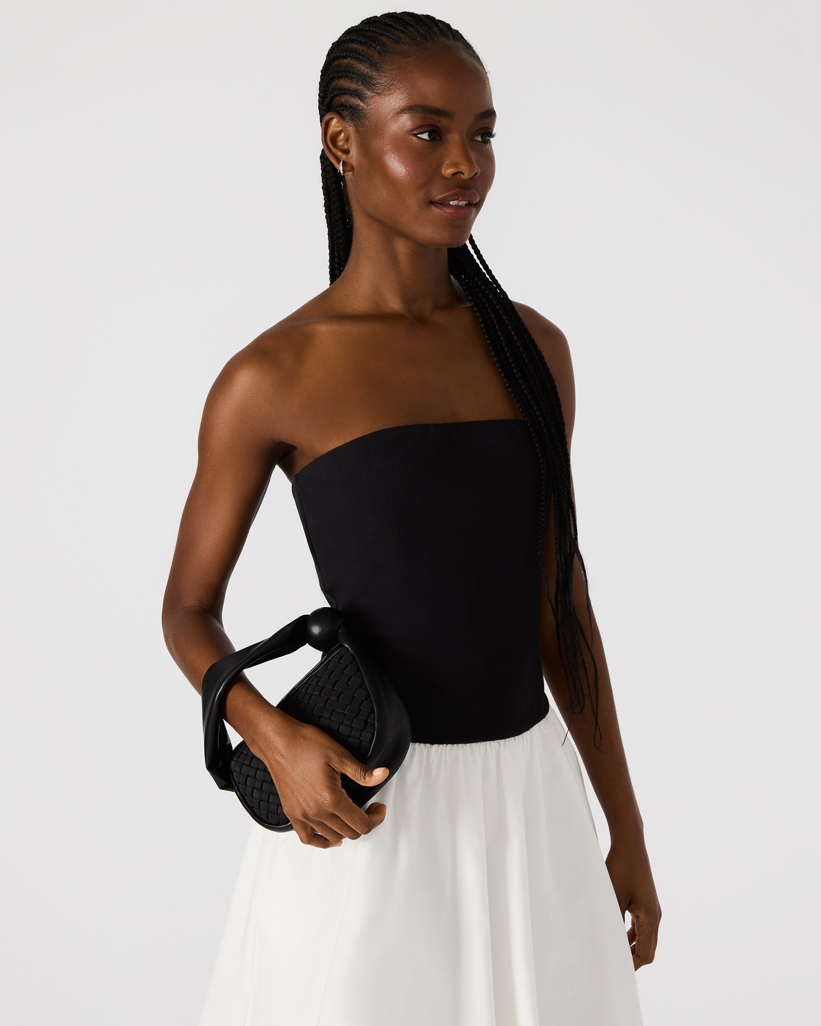 Close-up of the mini white bag with zipper detail.