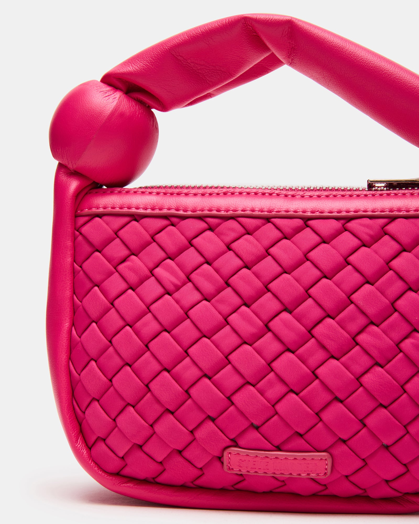 Close-up of the puffed handle on the fuchsia neoprene mini bag.