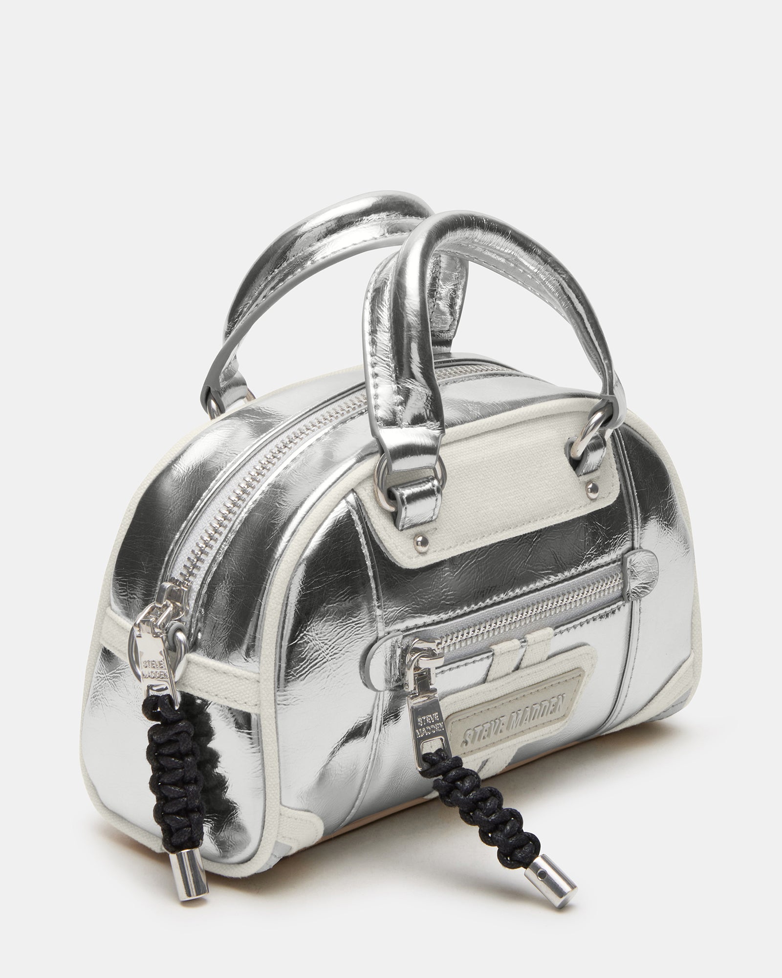 Close-up of the silver dome crossbody bags bungee zip and embossed logo patch