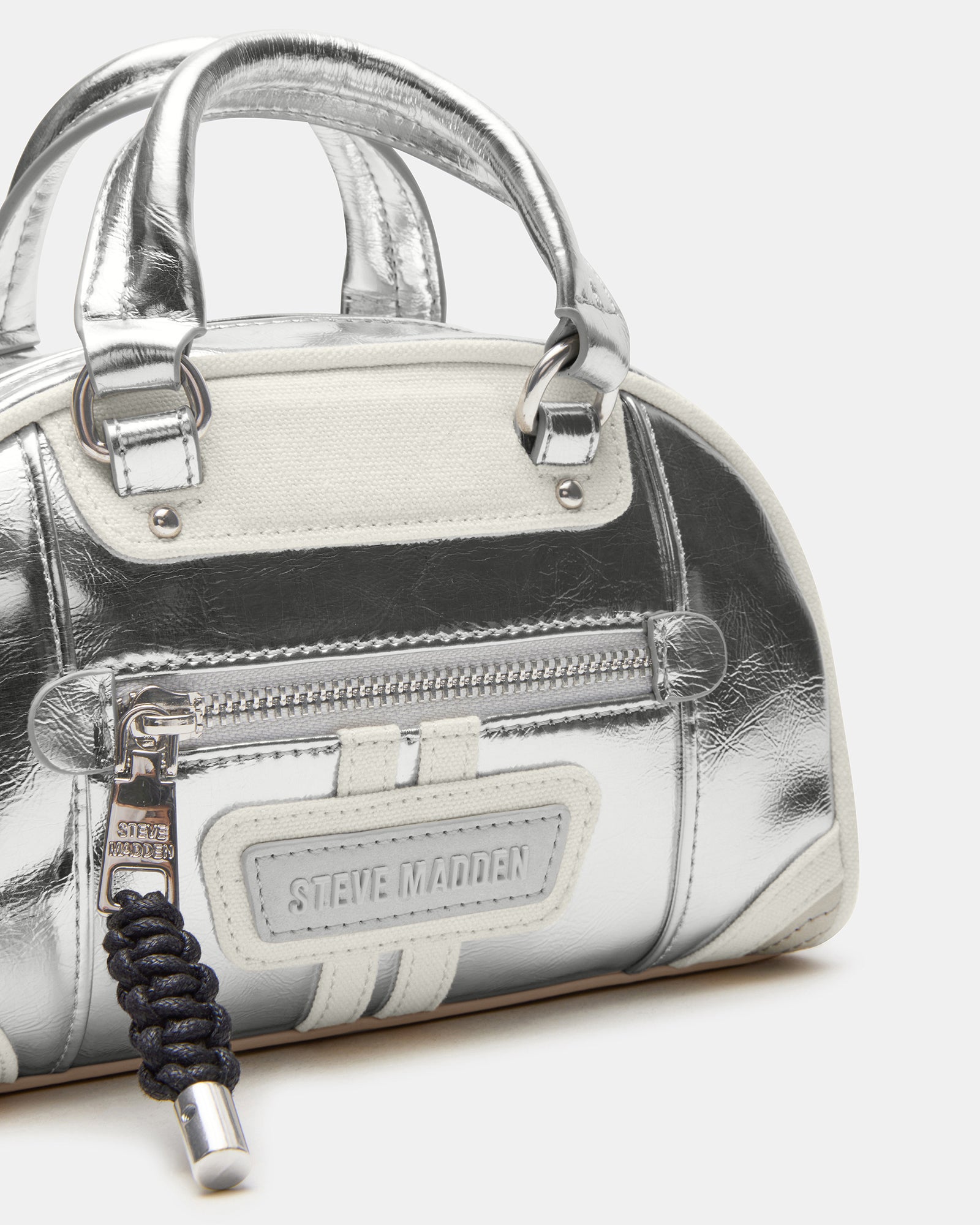 View of the dome crossbody bag laid flat with detachable straps visible
