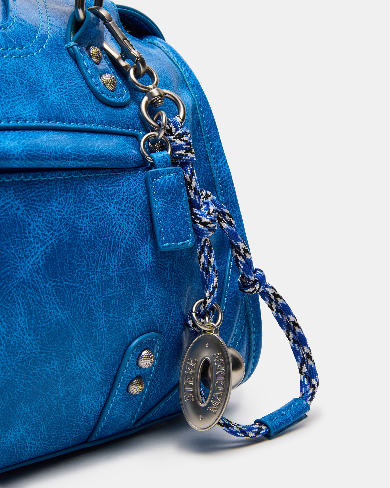 Close-up of the braided coach bag charm featuring bear and heart accents